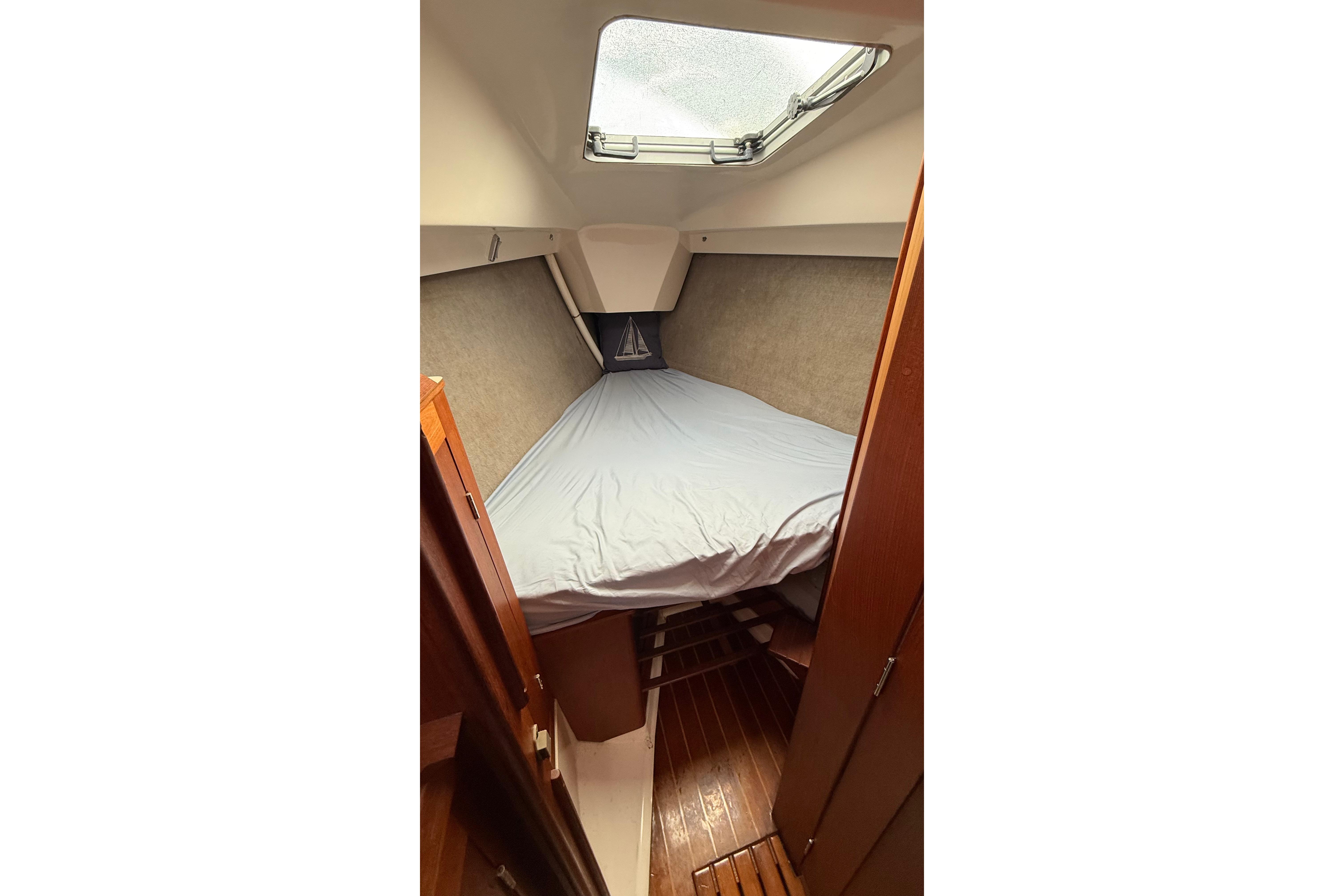 Cozy cabin interior of 1984 Hunter 31 sailboat with skylight and wooden flooring.