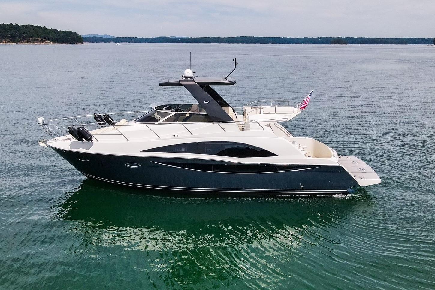 2011 Carver 44 Sojourn yacht on calm water, side view with American flag.