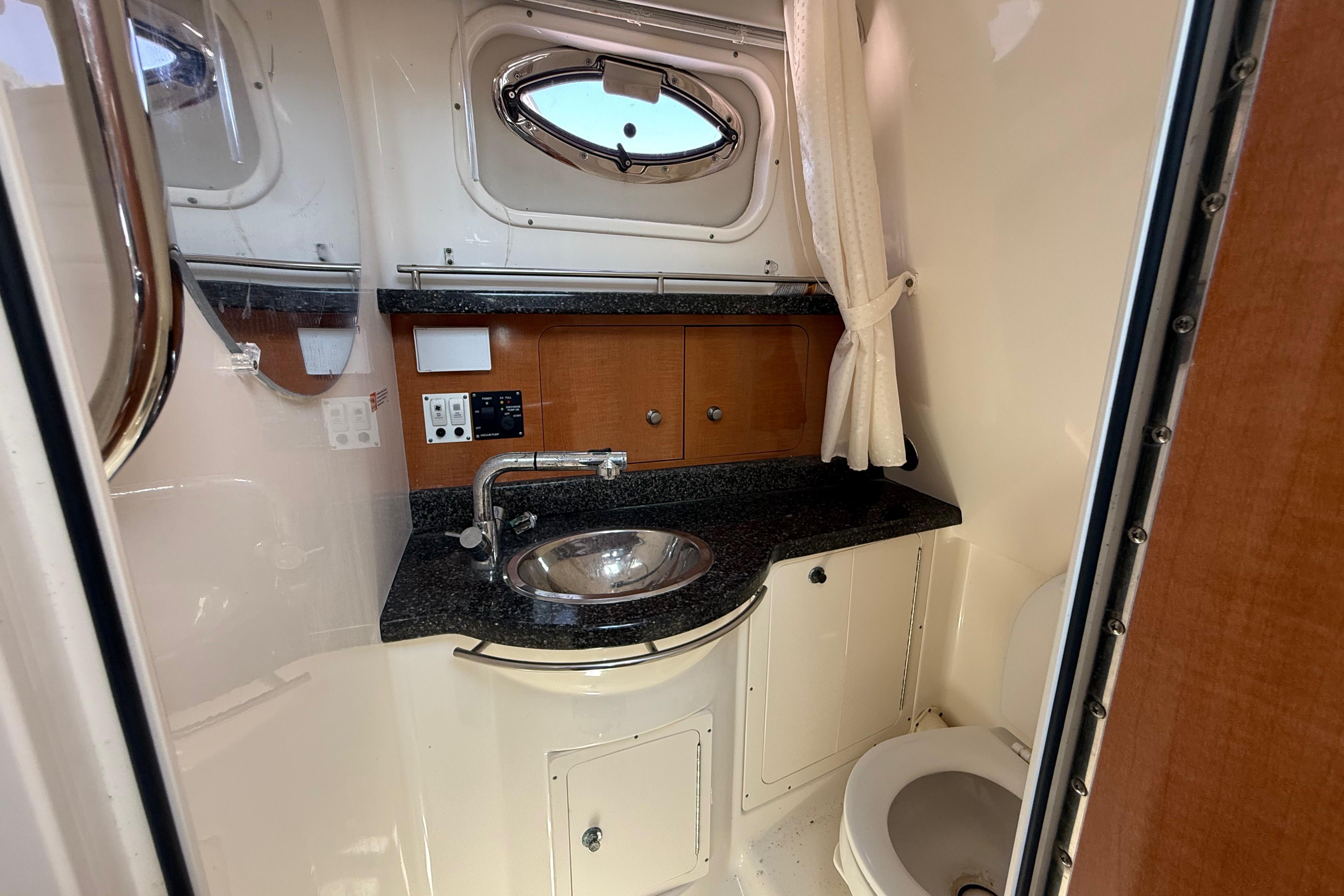 2007 Robalo R305 Walkaround boat bathroom with sink, mirror, and toilet.
