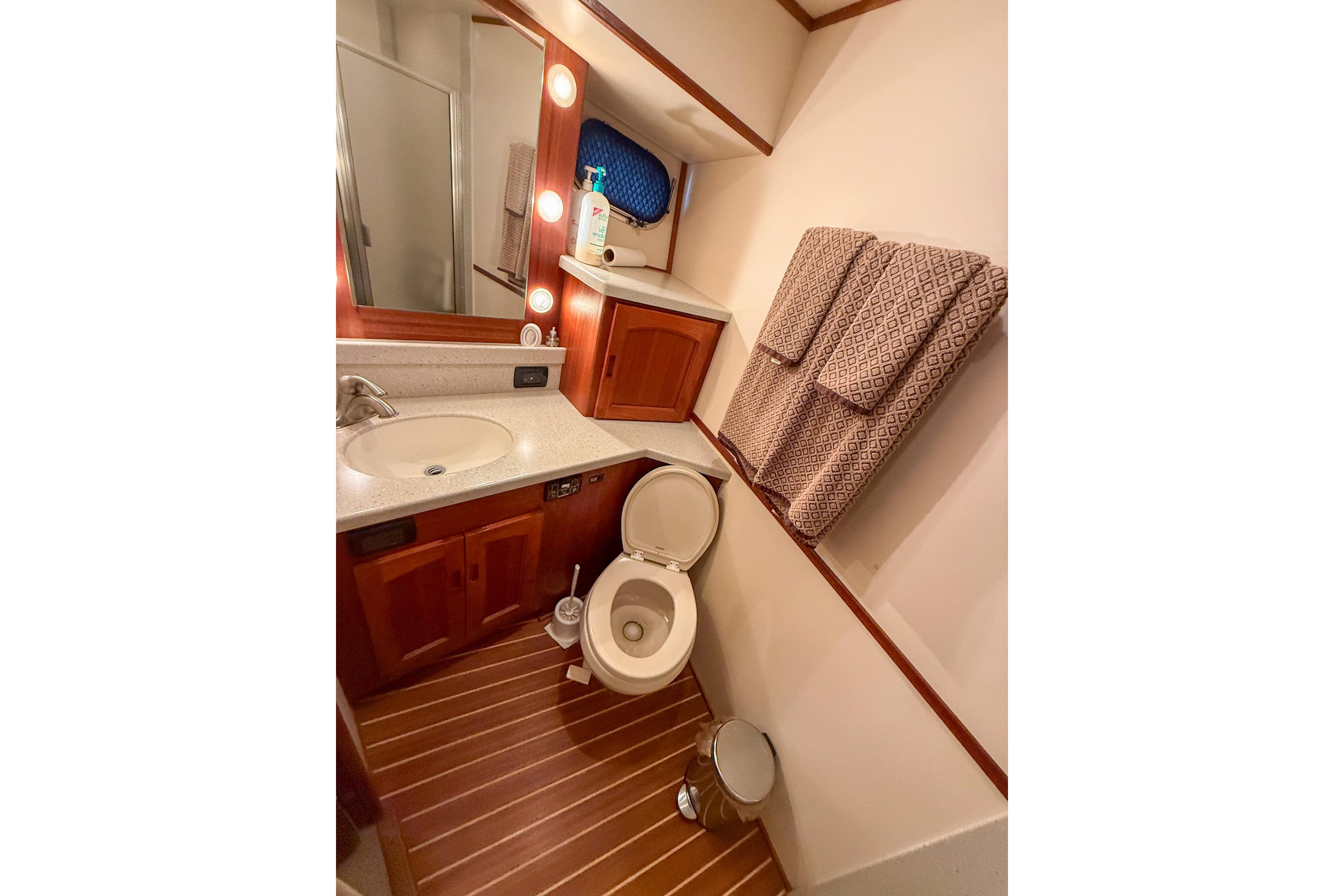 Luxurious bathroom in 2007 Nordic Tug 54 yacht with wooden flooring and modern fixtures.