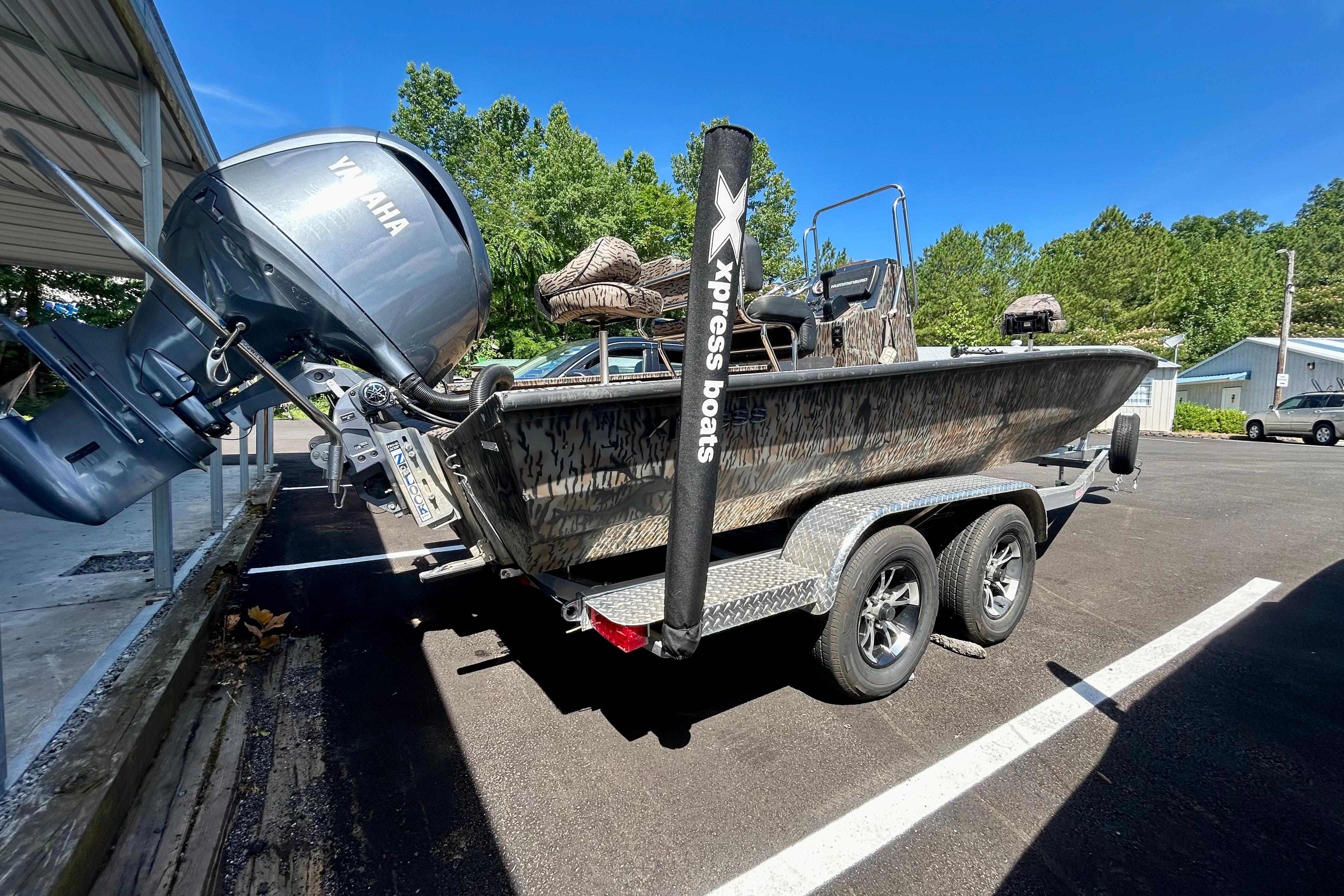 2025 Xpress H22B Bay boat on trailer with Yamaha outboard motor, parked outdoors.