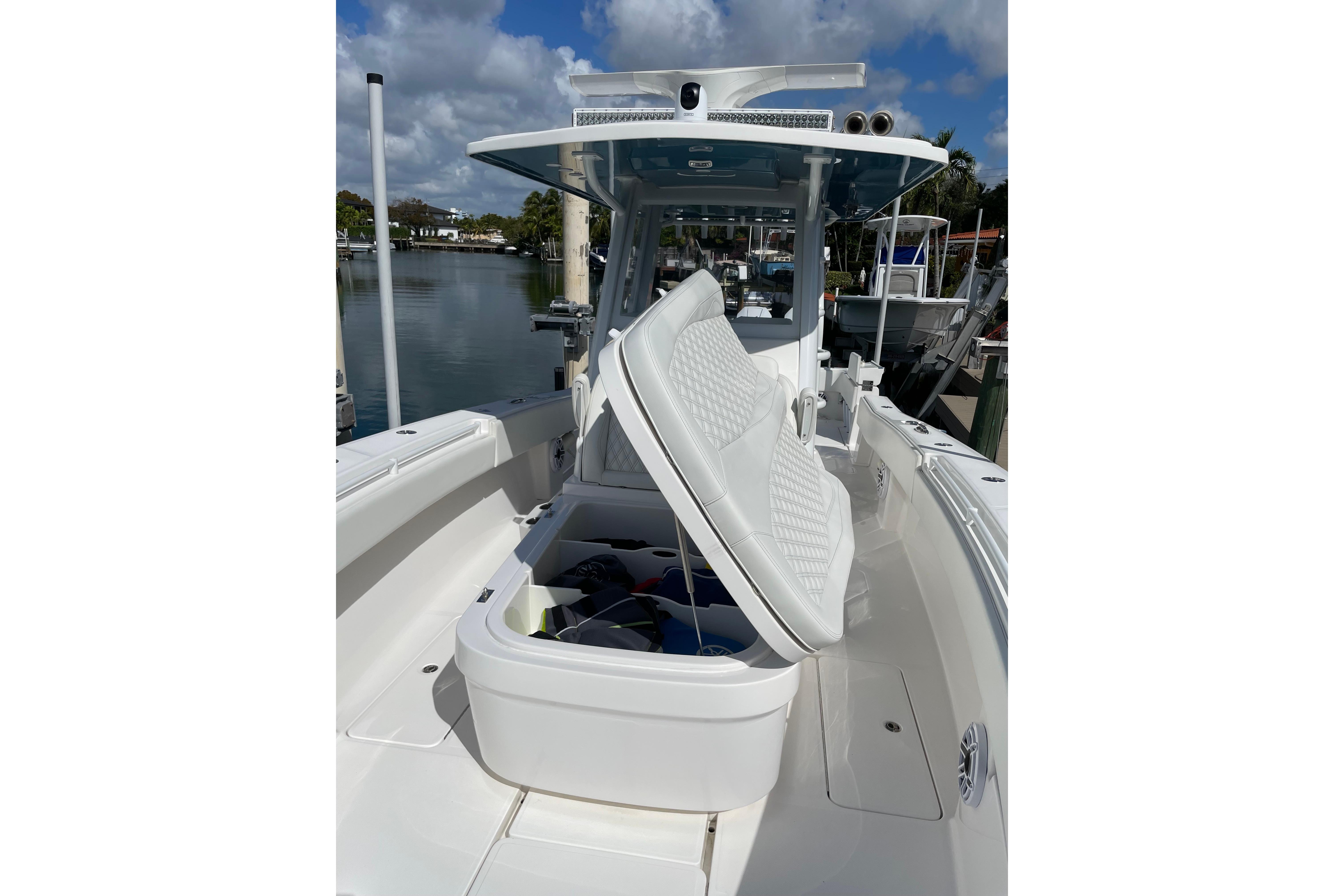 2024 Invincible 36 Open Fisherman boat with open storage compartment, docked by the water.