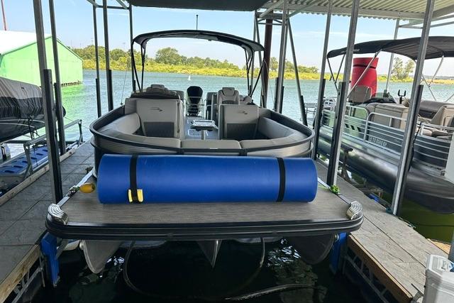 2021 Bennington L Bowrider 25 Quad Bench pontoon boat docked at marina.
