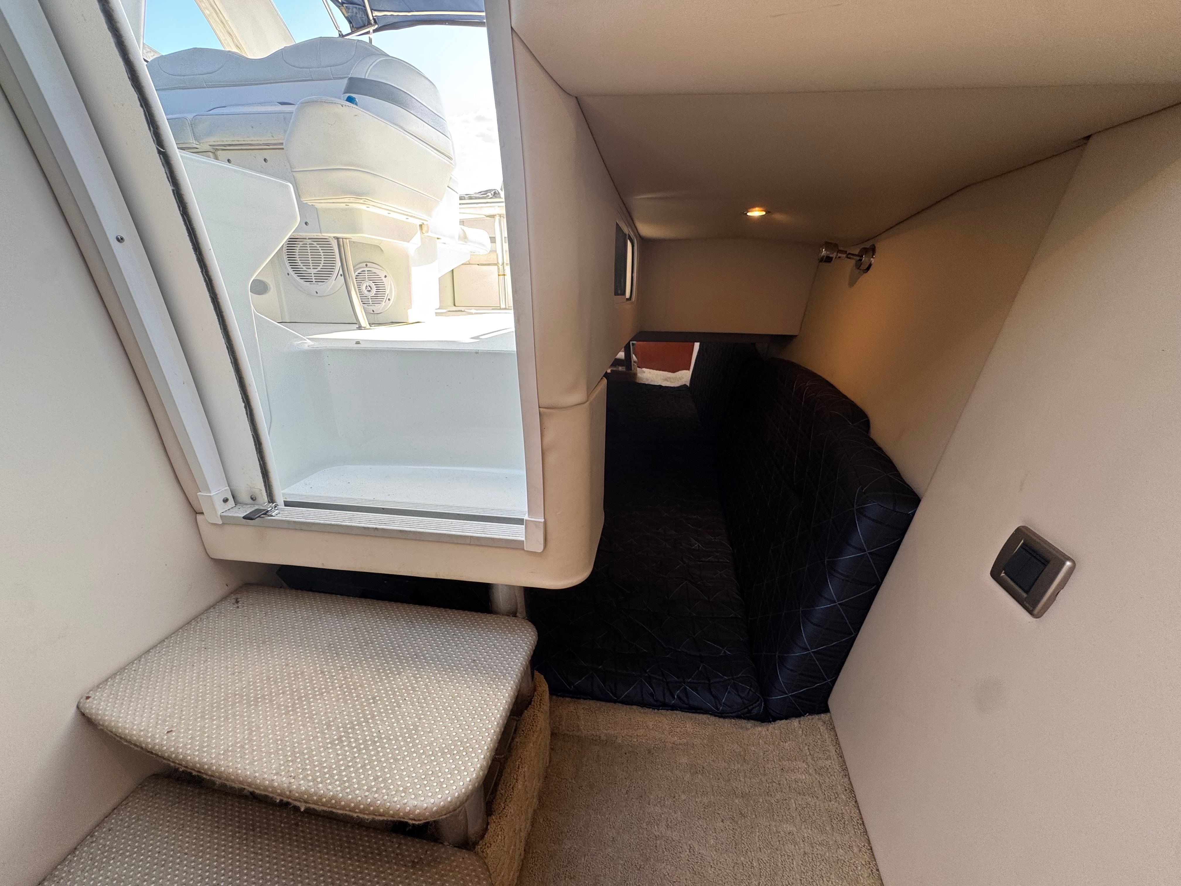 Interior of a yacht with stairs and a cushioned seating area.
