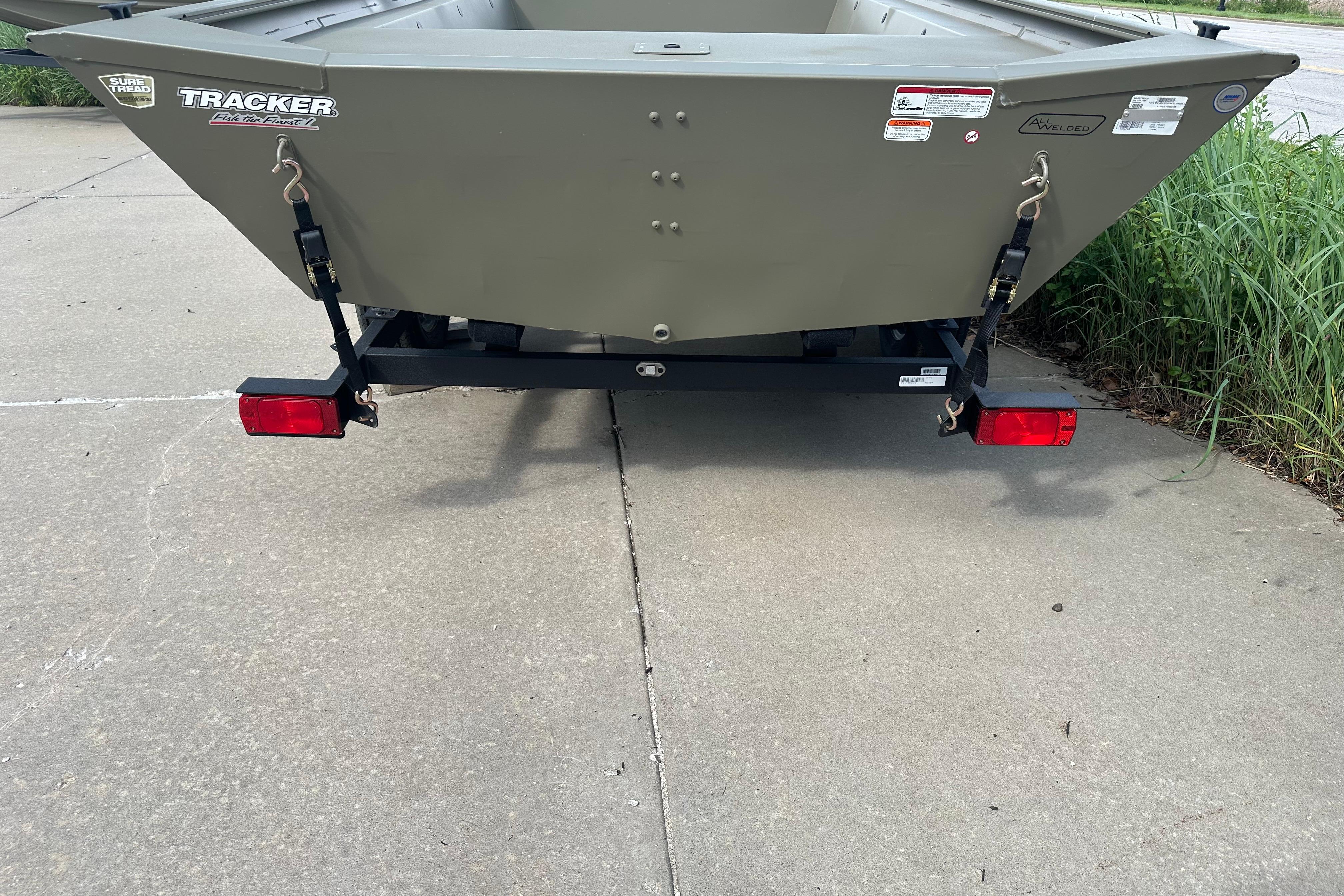 2026 Tracker Grizzly 1754 Utility boat on trailer, parked on concrete surface.