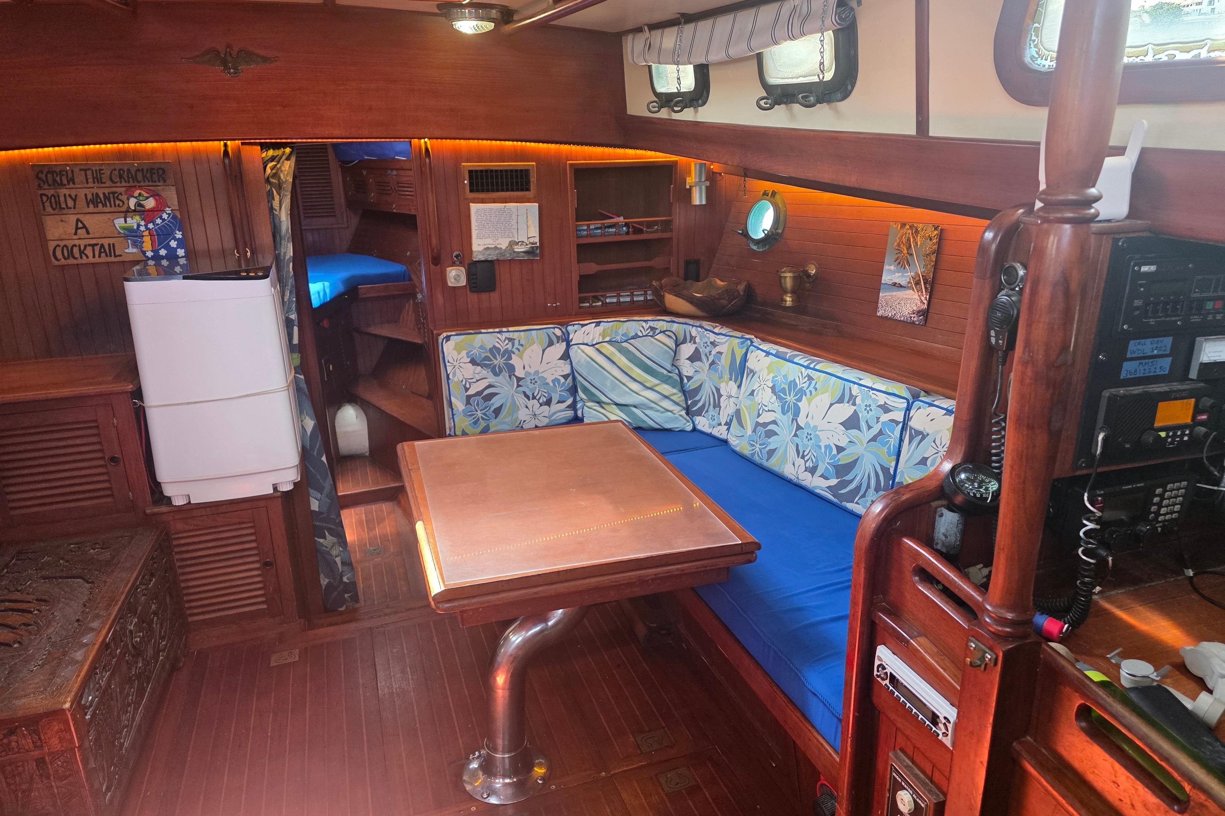 Interior of 1983 Vagabond 47 sailboat with cozy seating and wooden decor.
