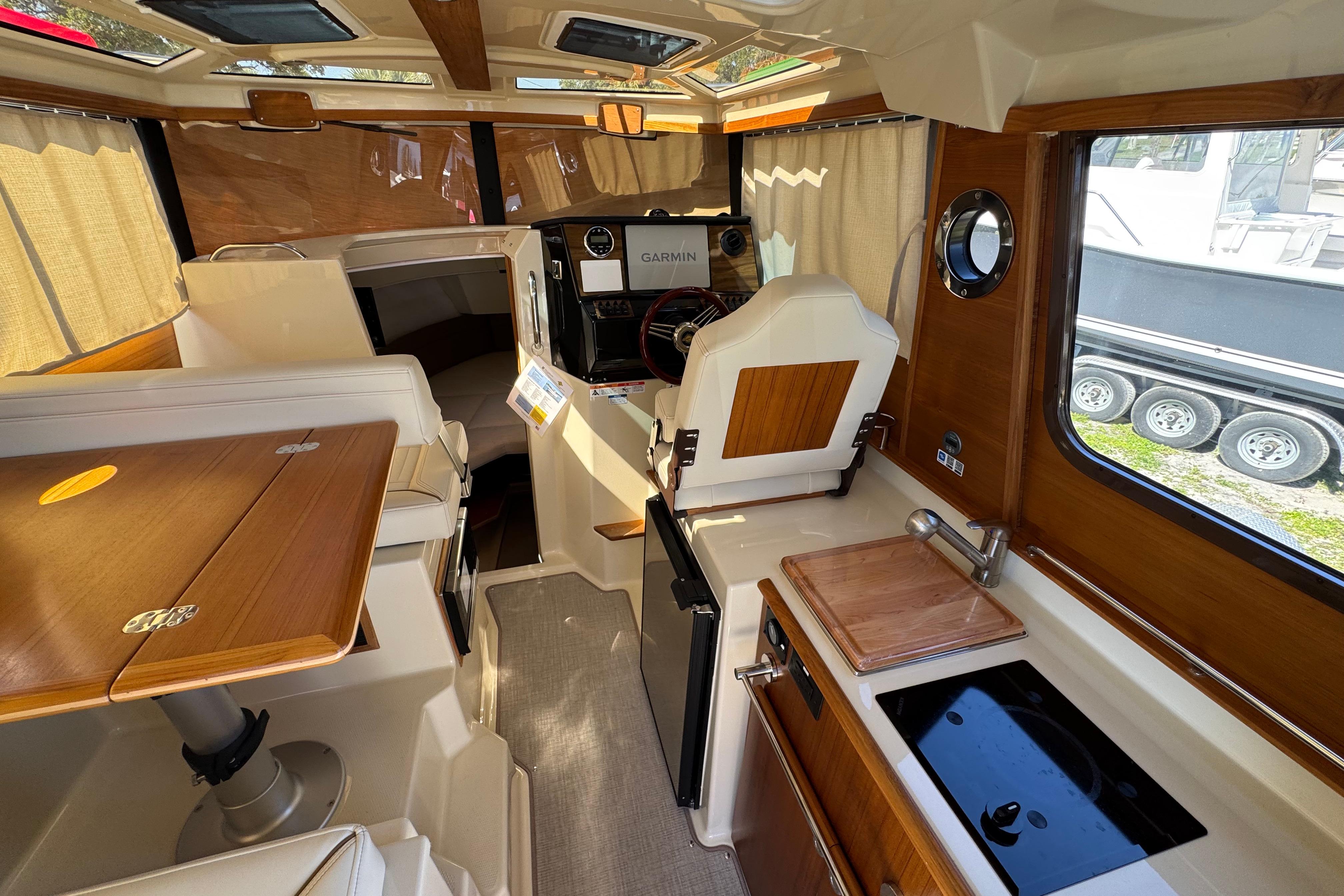 Interior of 2026 Ranger Tugs R-25 boat with wood accents and modern amenities.