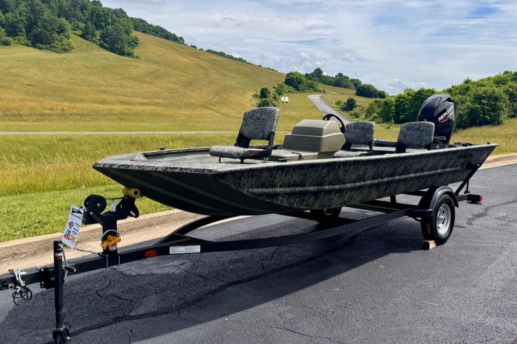 2026 Tracker Grizzly 1754 SC boat on trailer, scenic countryside background.