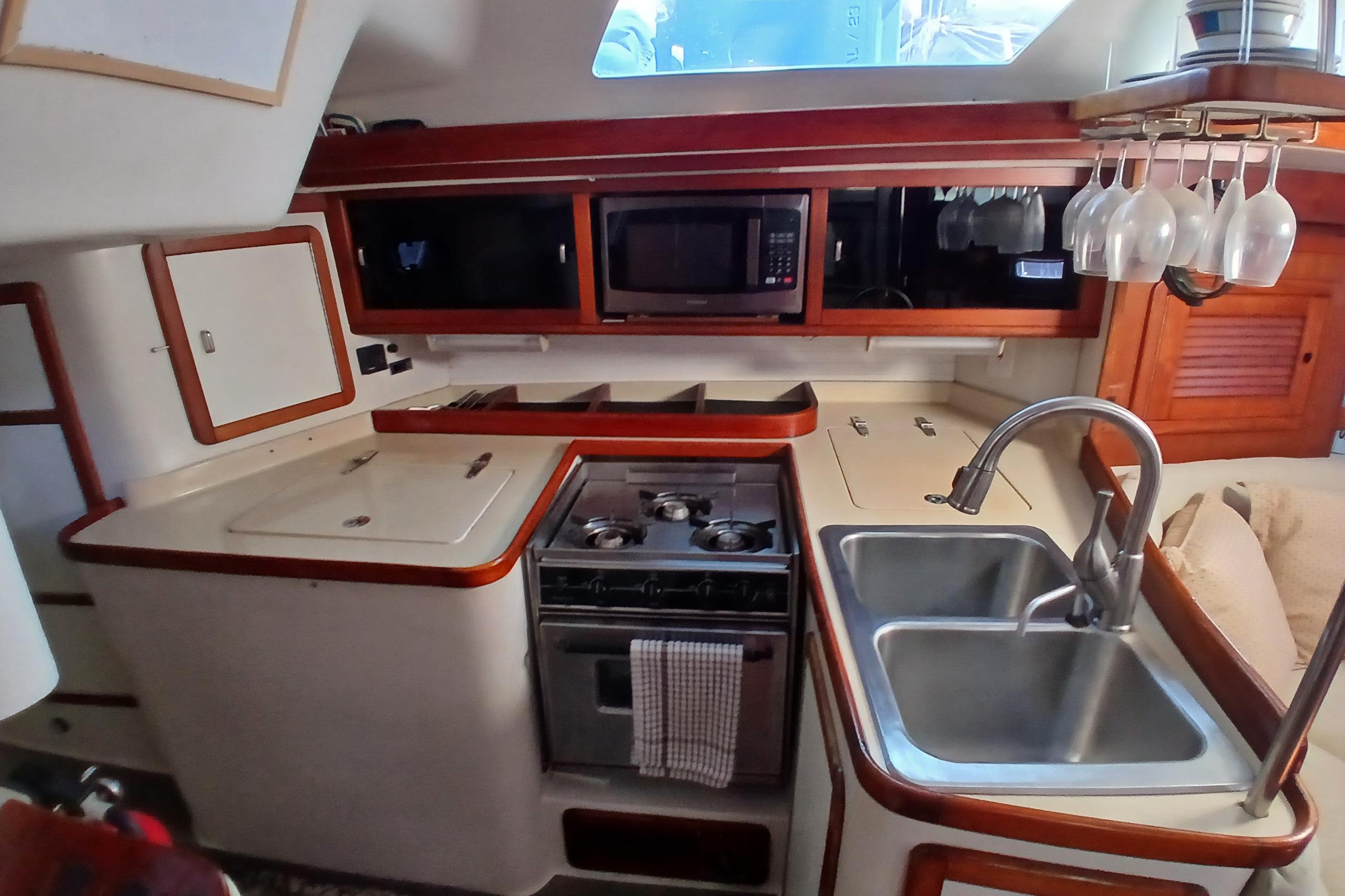 Galley kitchen in 1995 Catalina 42 MkII sailboat with stove, sink, and microwave.