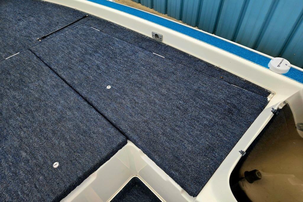 1996 Champion 181 SX boat deck with blue carpet and storage compartments.