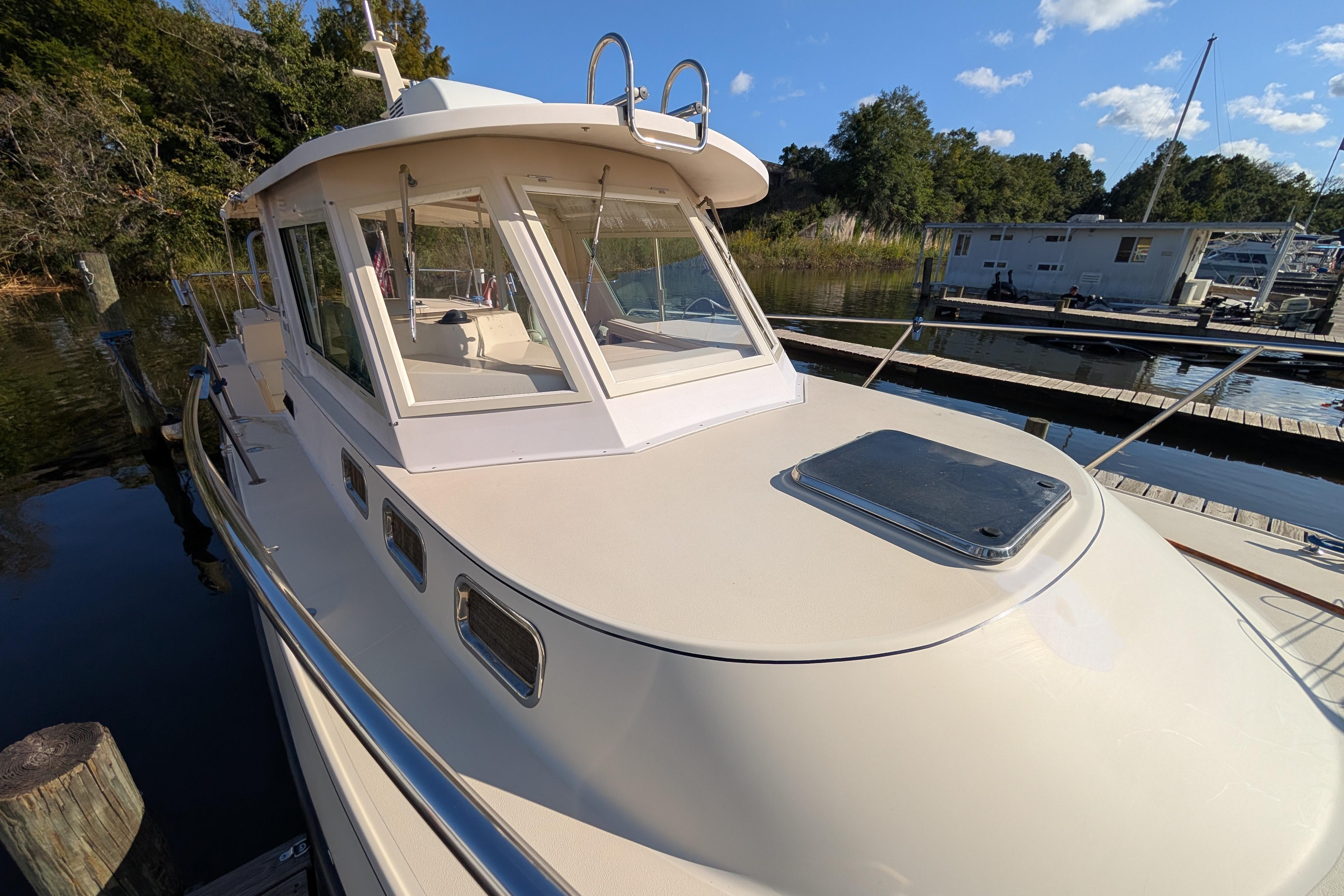 2004 Albin 30 Family Cruiser docked at marina, sunny day, surrounded by trees and water.