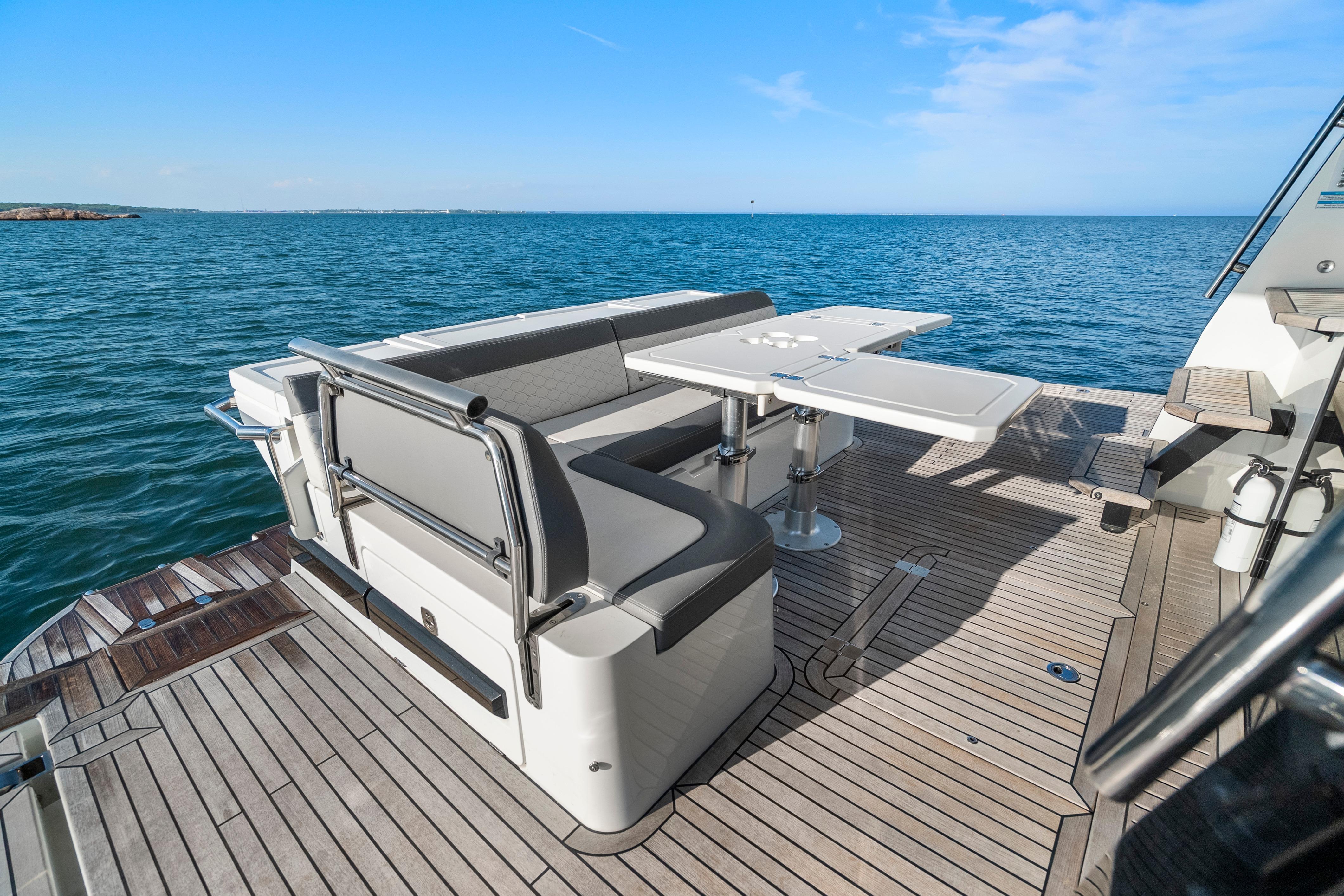2023 Galeon 400 Fly yacht deck with seating and table, overlooking the ocean.