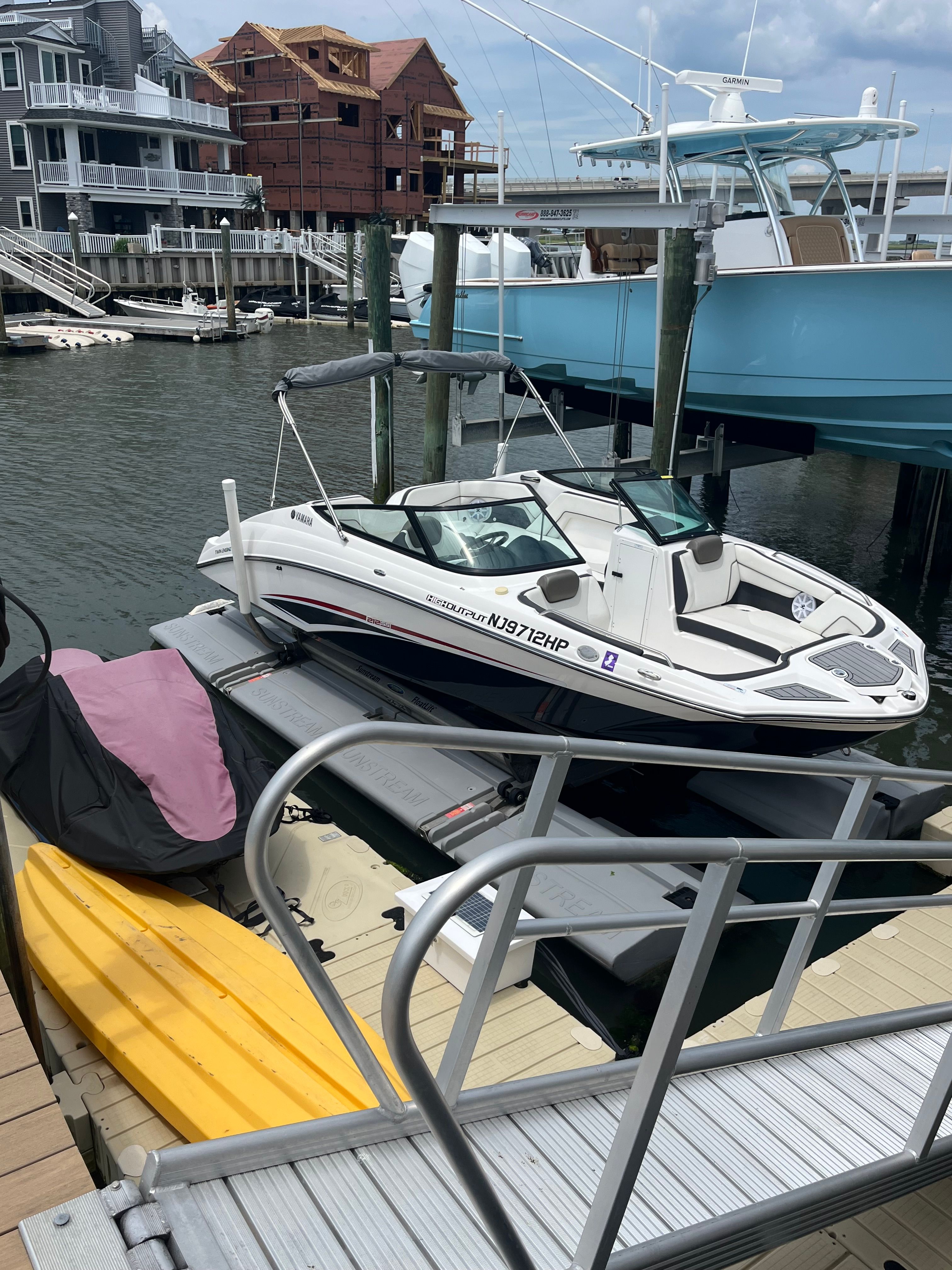 A Yamaha 212SS boat is on a lift in a marina.
