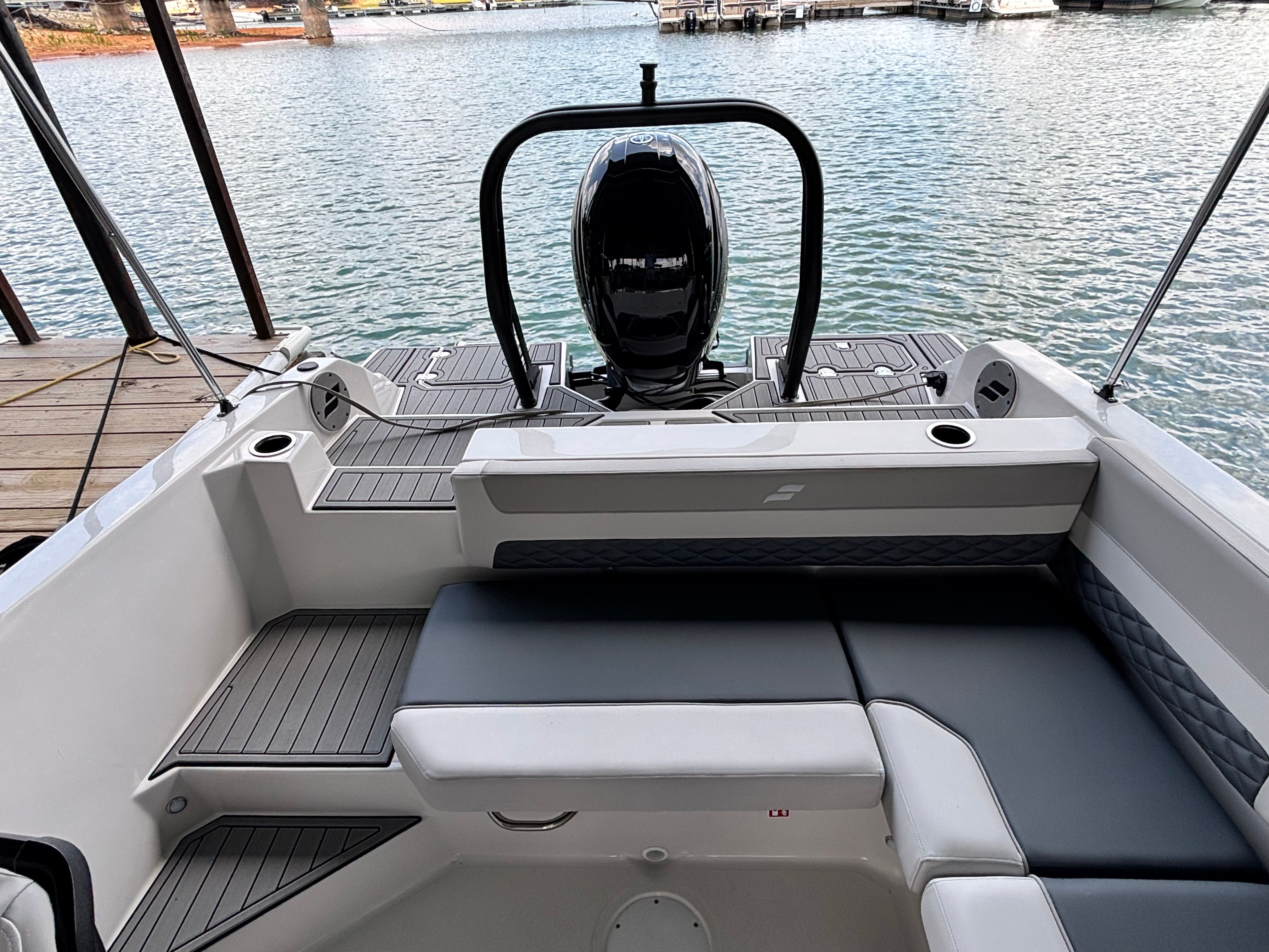 The image shows the stern of a 2027 Starcraft 211SVXOB boat docked at a pier.