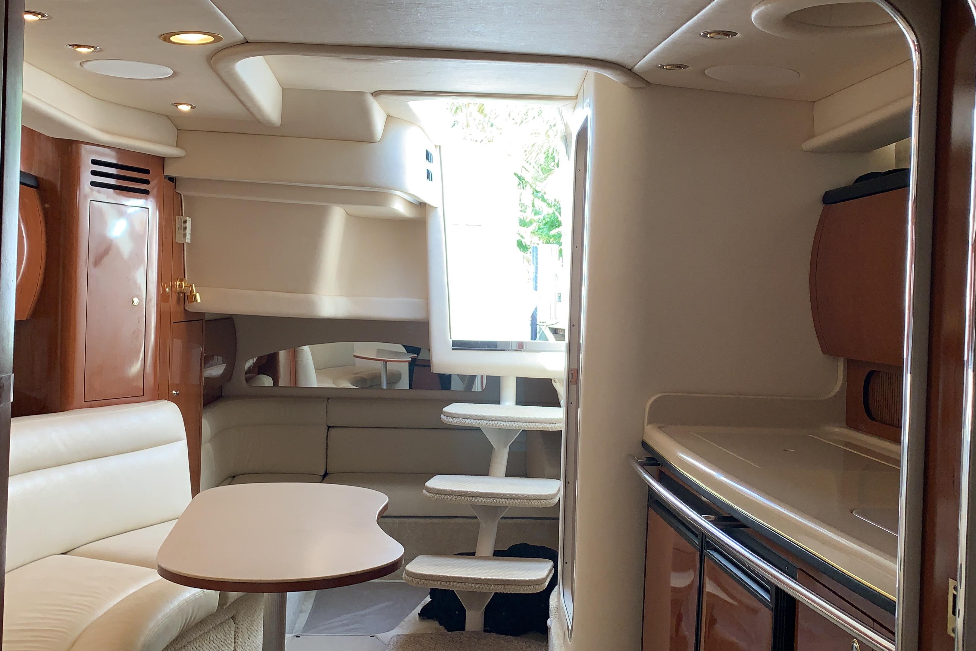 Interior of 2002 Sea Ray 360 Sundancer yacht, featuring elegant seating and modern cabinetry.