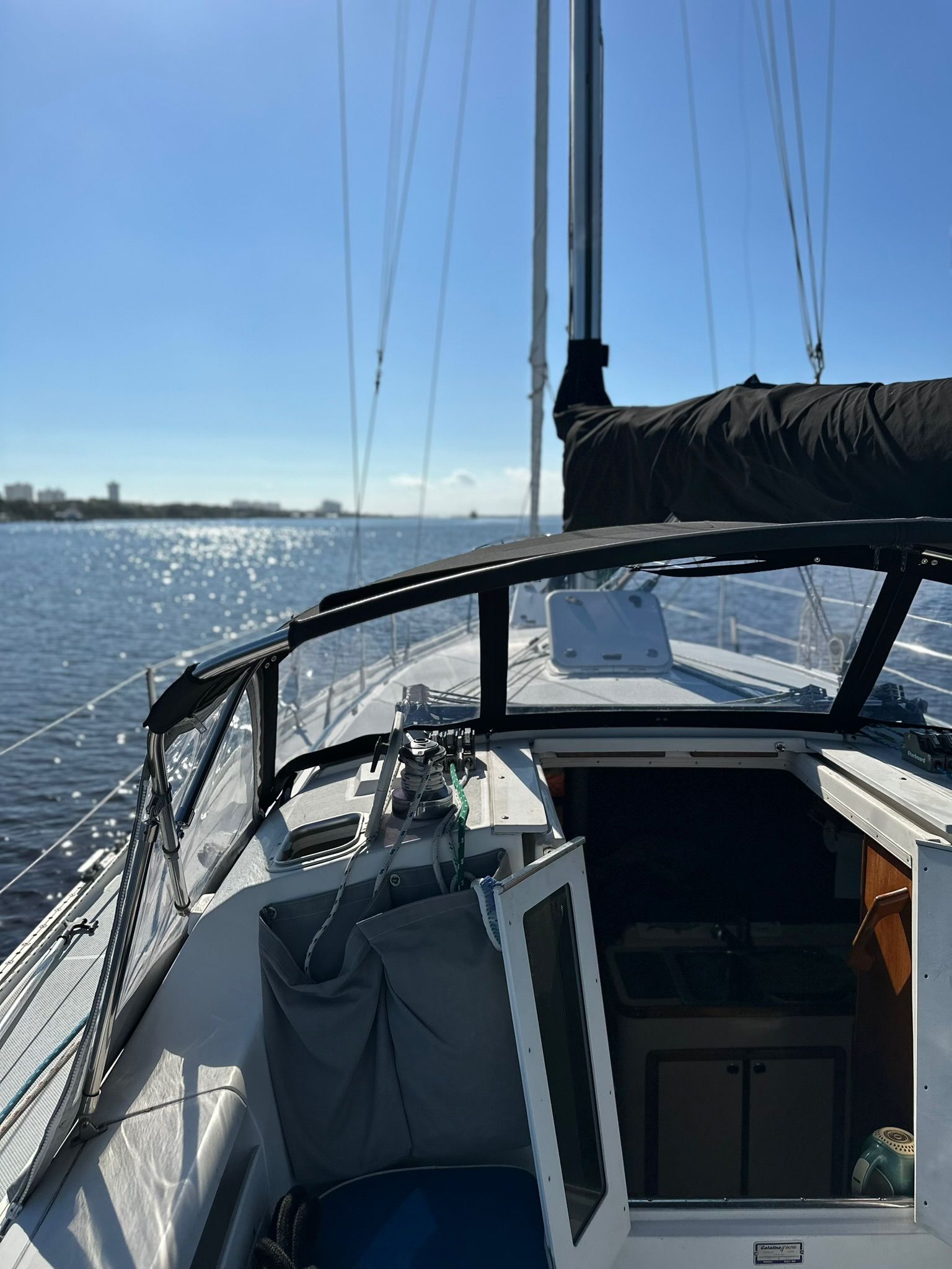 Sailboat on calm water with clear sky.