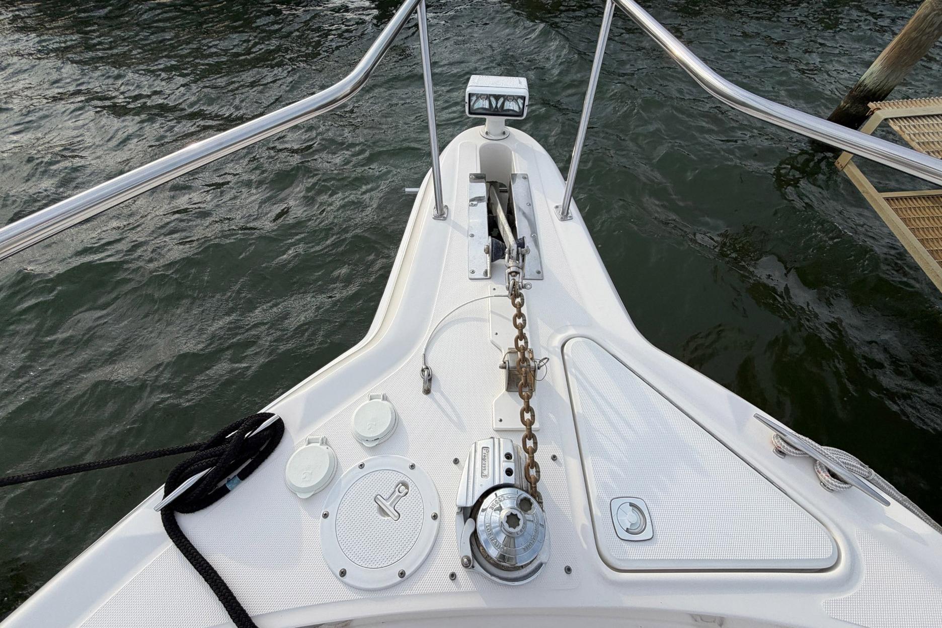 Bow of 2000 Sea Ray Sundancer 460 yacht with anchor chain and water view.