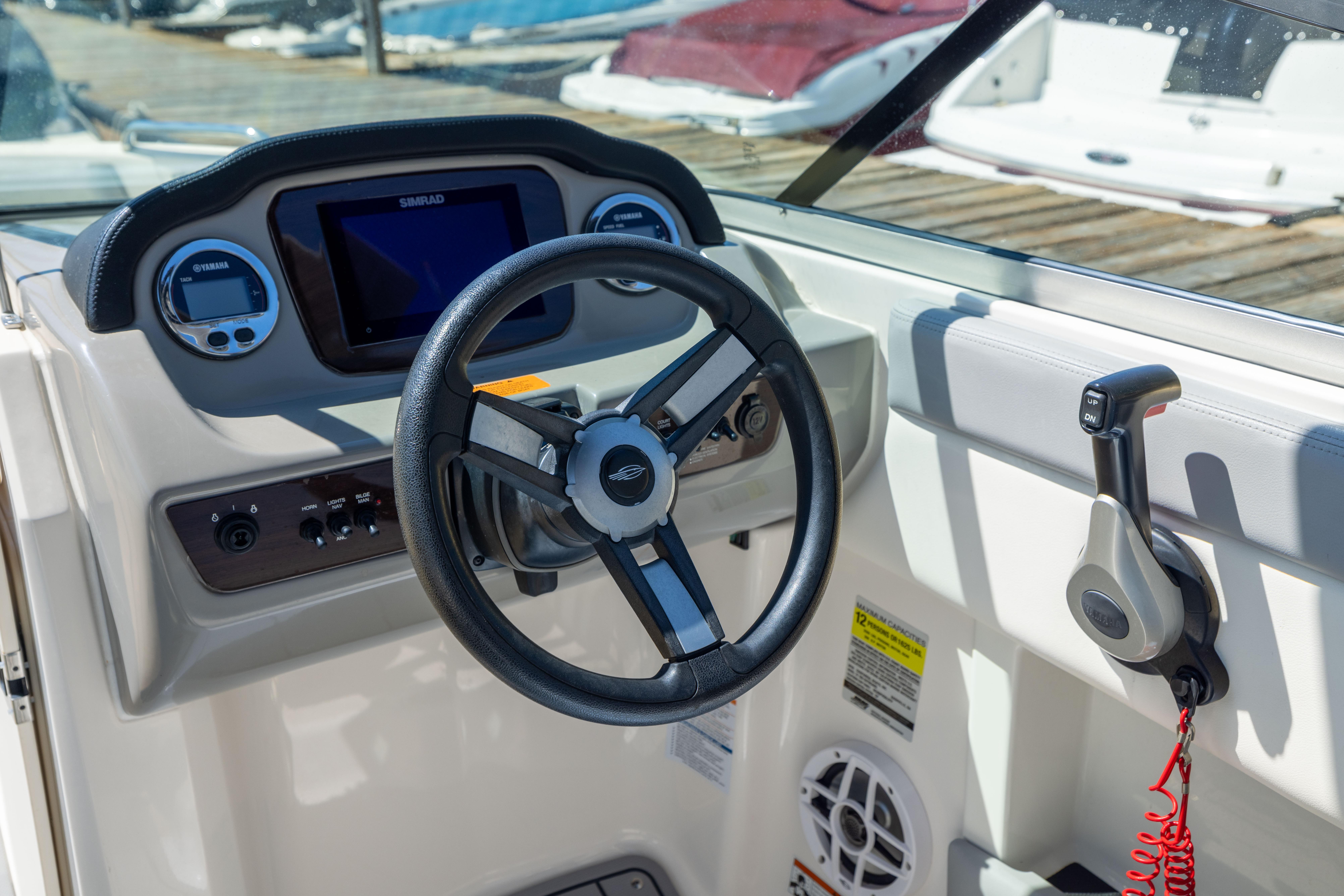 Cockpit view of 2022 Chaparral 21 SSi OB boat with steering wheel and controls.