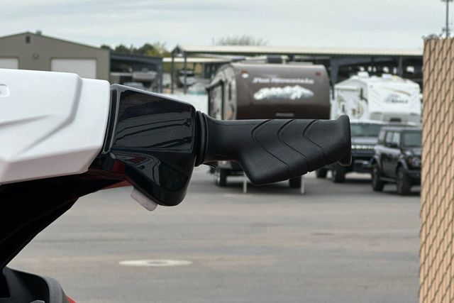 Close-up of a black handle on a Sea-Doo watercraft, with RVs in the background.