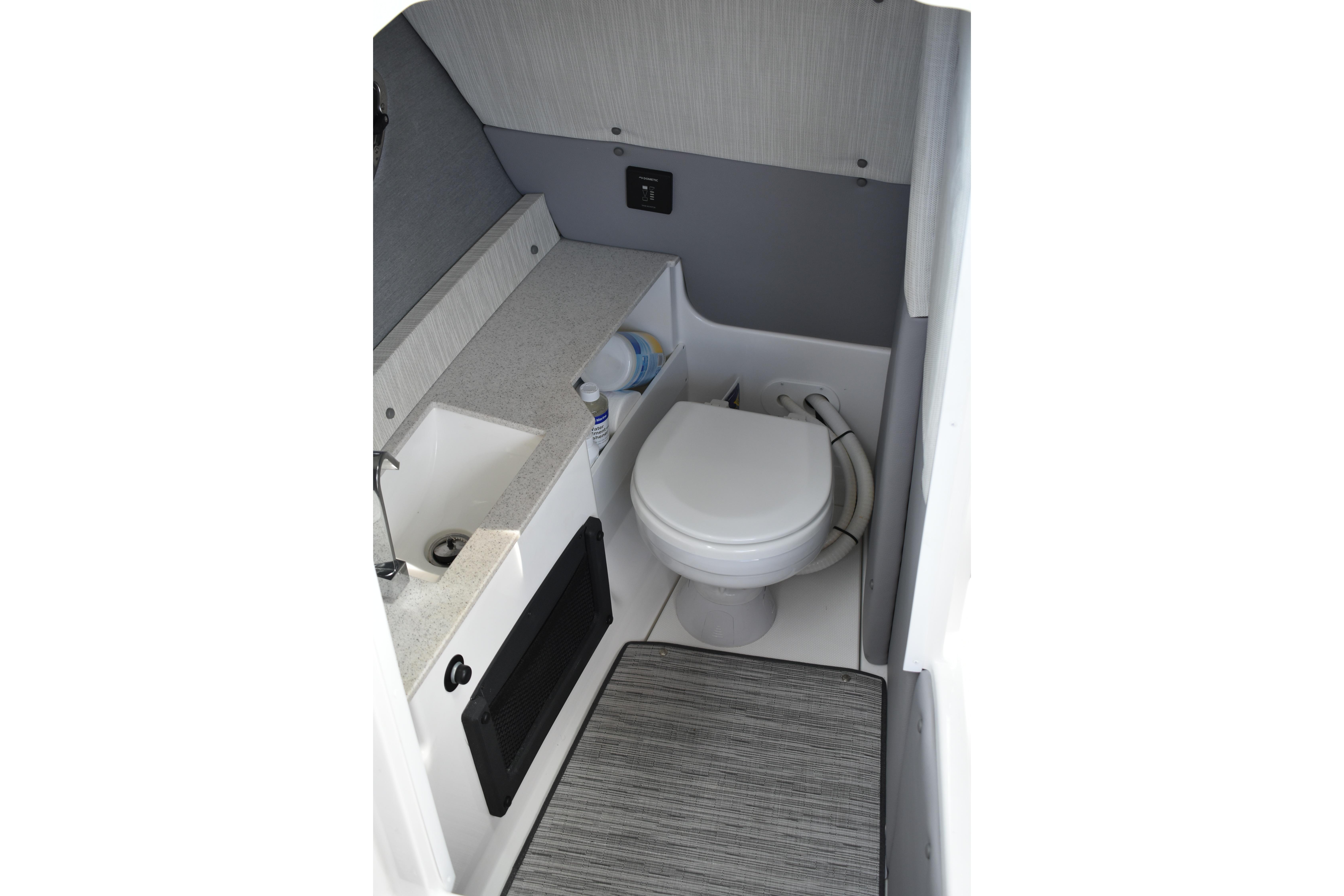 2023 Cobalt R8 boat interior bathroom with sink, toilet, and storage space.