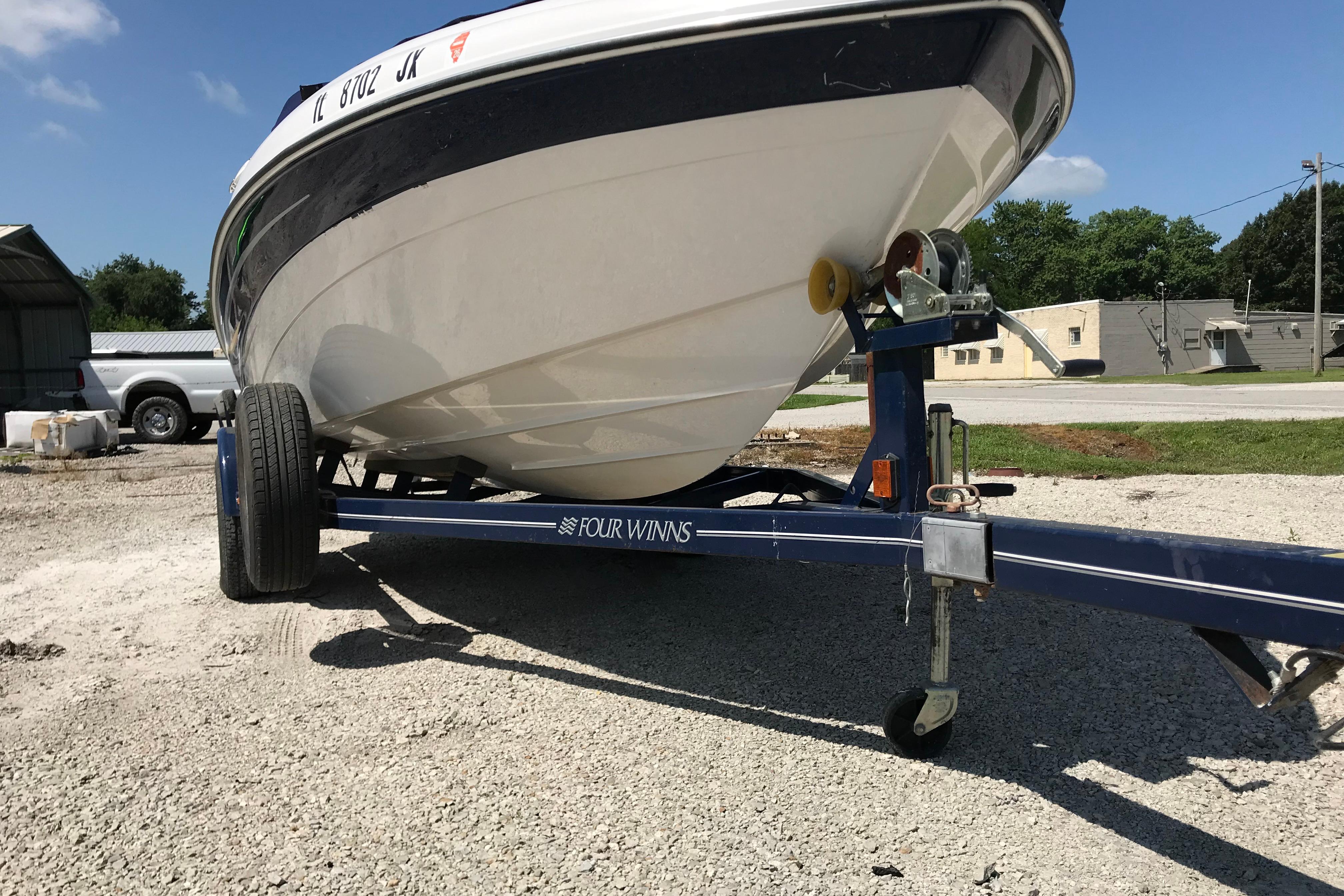 2005 Four Winns 180 Horizon FS boat on trailer, parked outdoors on gravel.