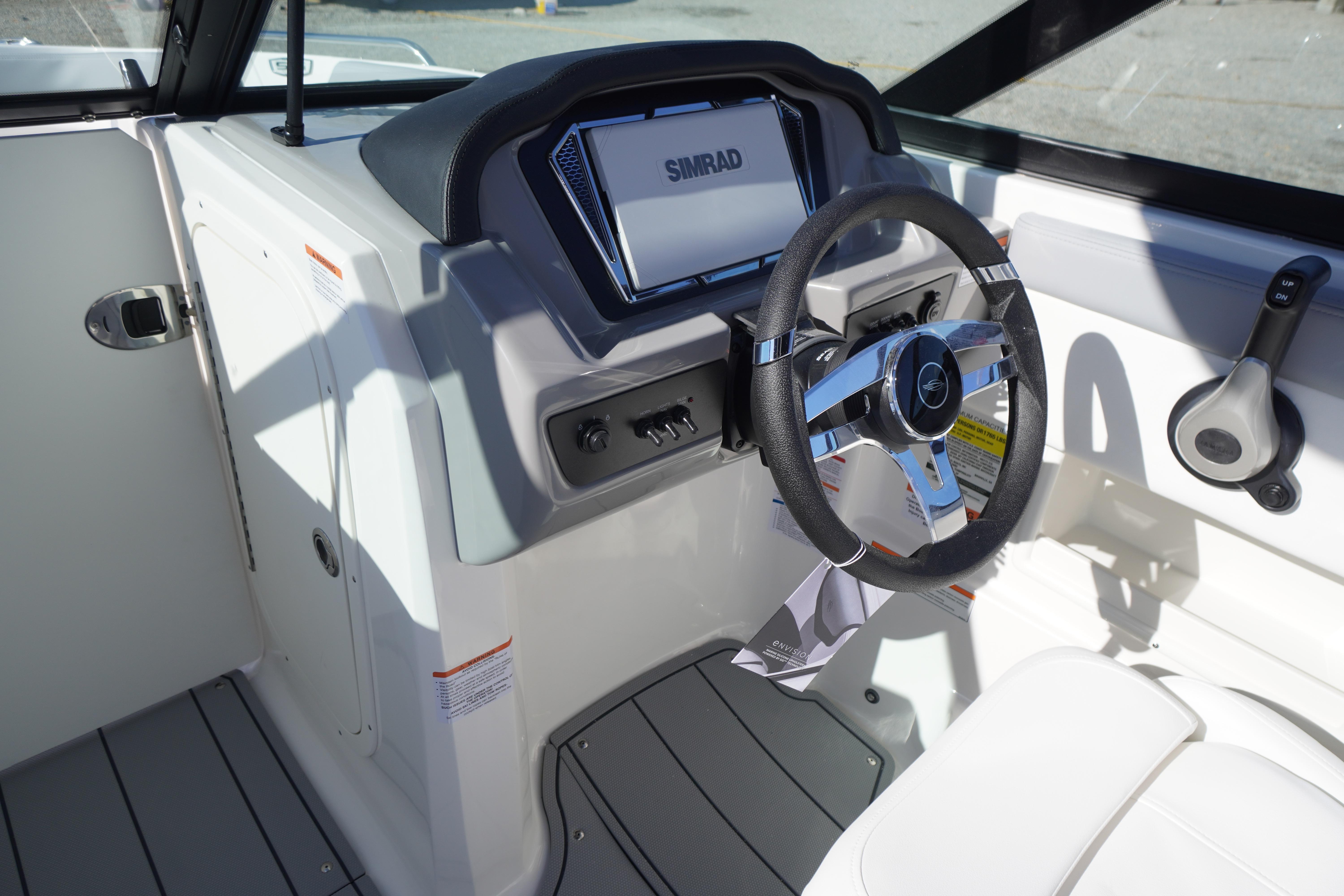 2026 Chaparral 23 SSi OB boat cockpit with steering wheel and Simrad display.