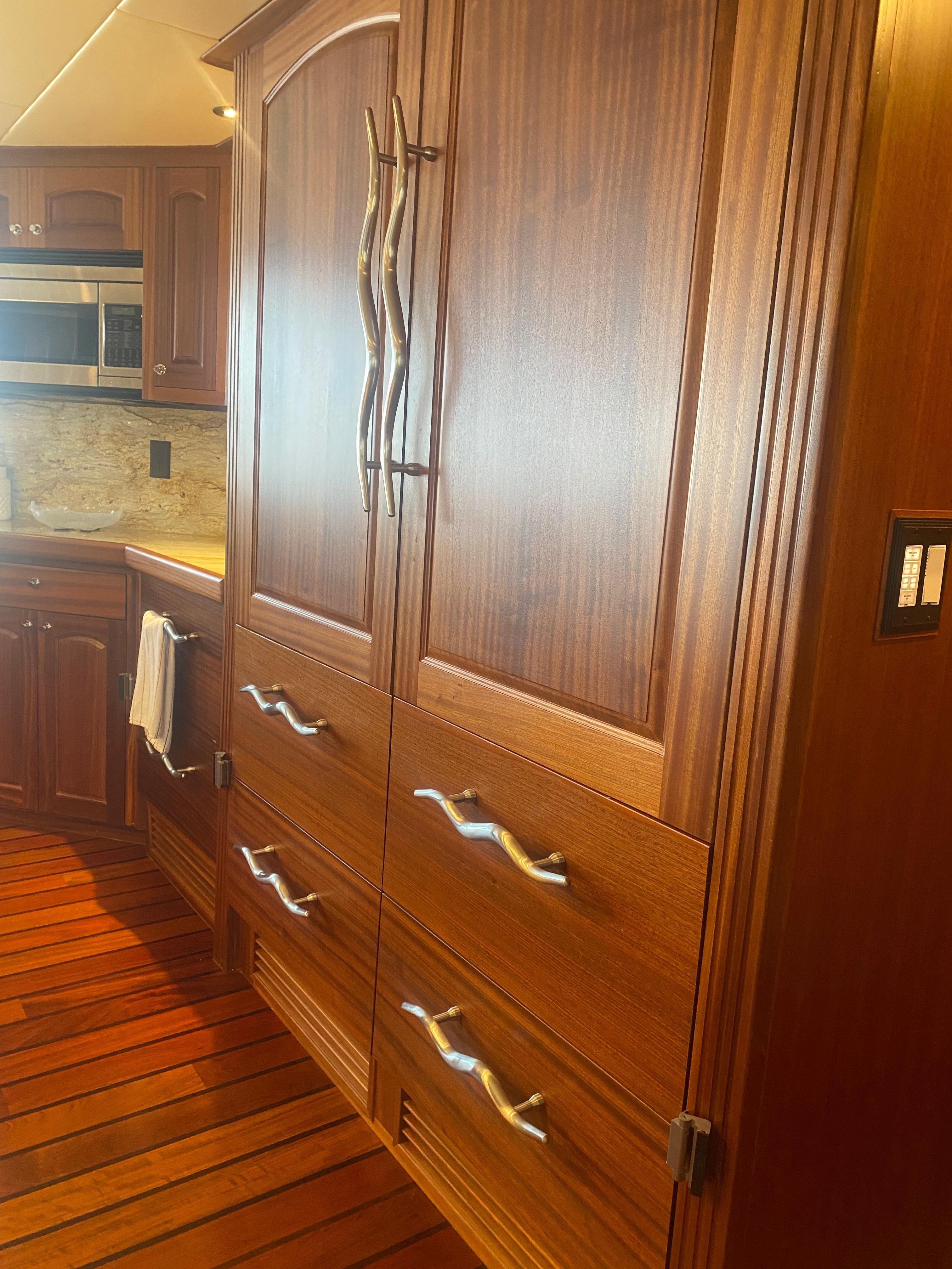Luxurious wooden kitchen cabinetry in 2018 Allseas Expedition yacht, featuring modern handles and sleek design.