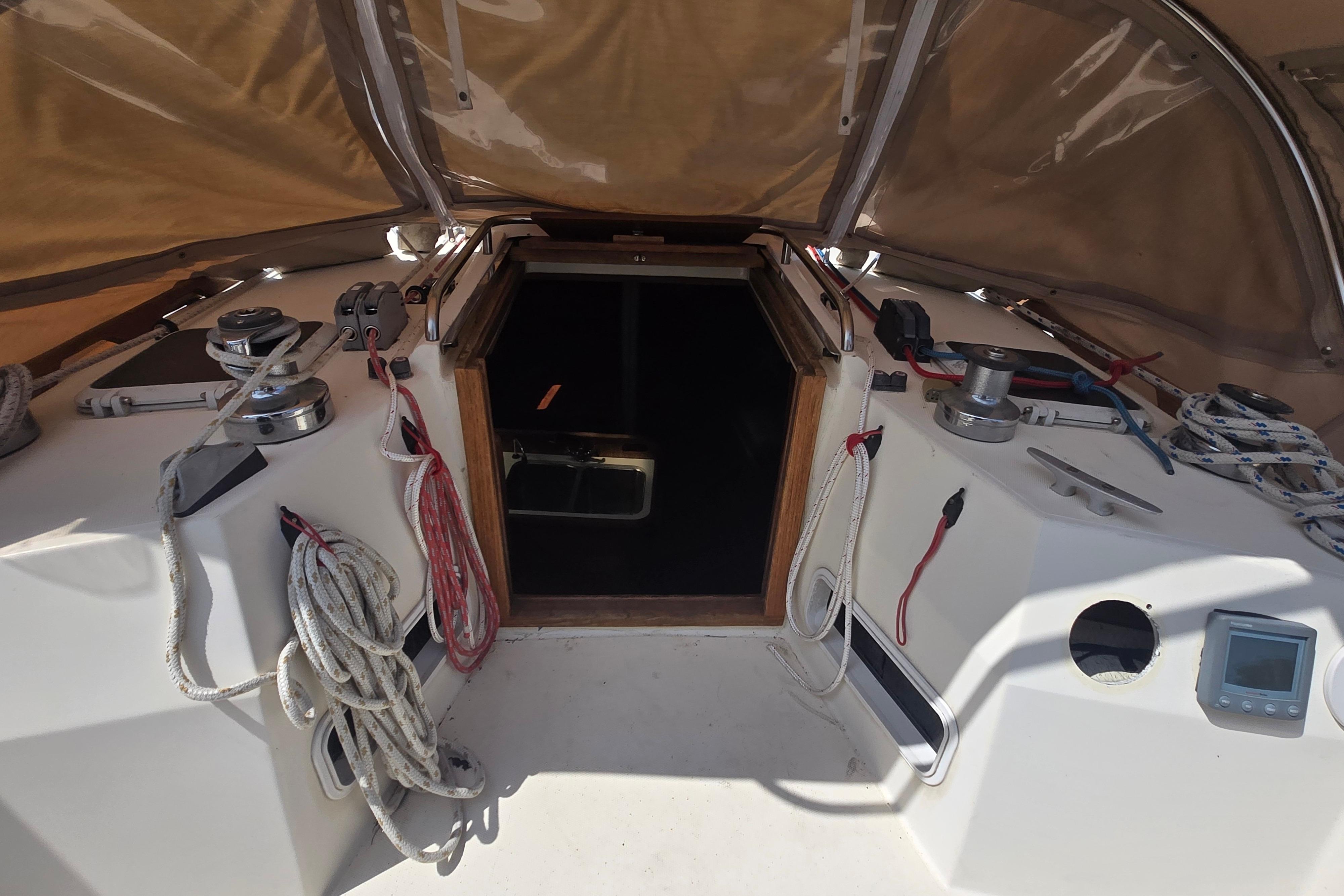 Cockpit of 1988 Sabre 38 sailboat with ropes, winches, and open hatch.