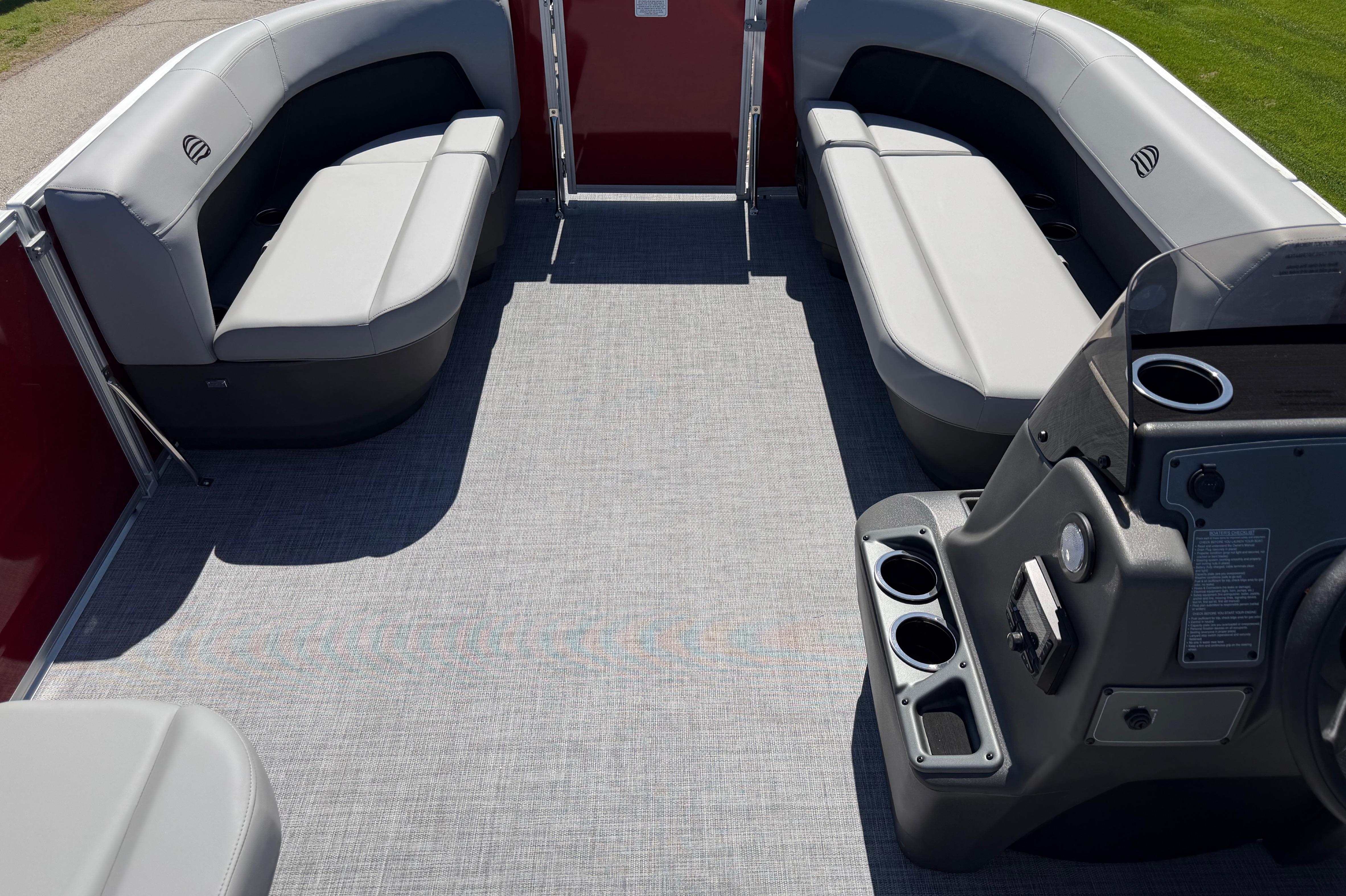 2026 Sun Tracker Party Barge 16 DLX interior with gray seating and control console.