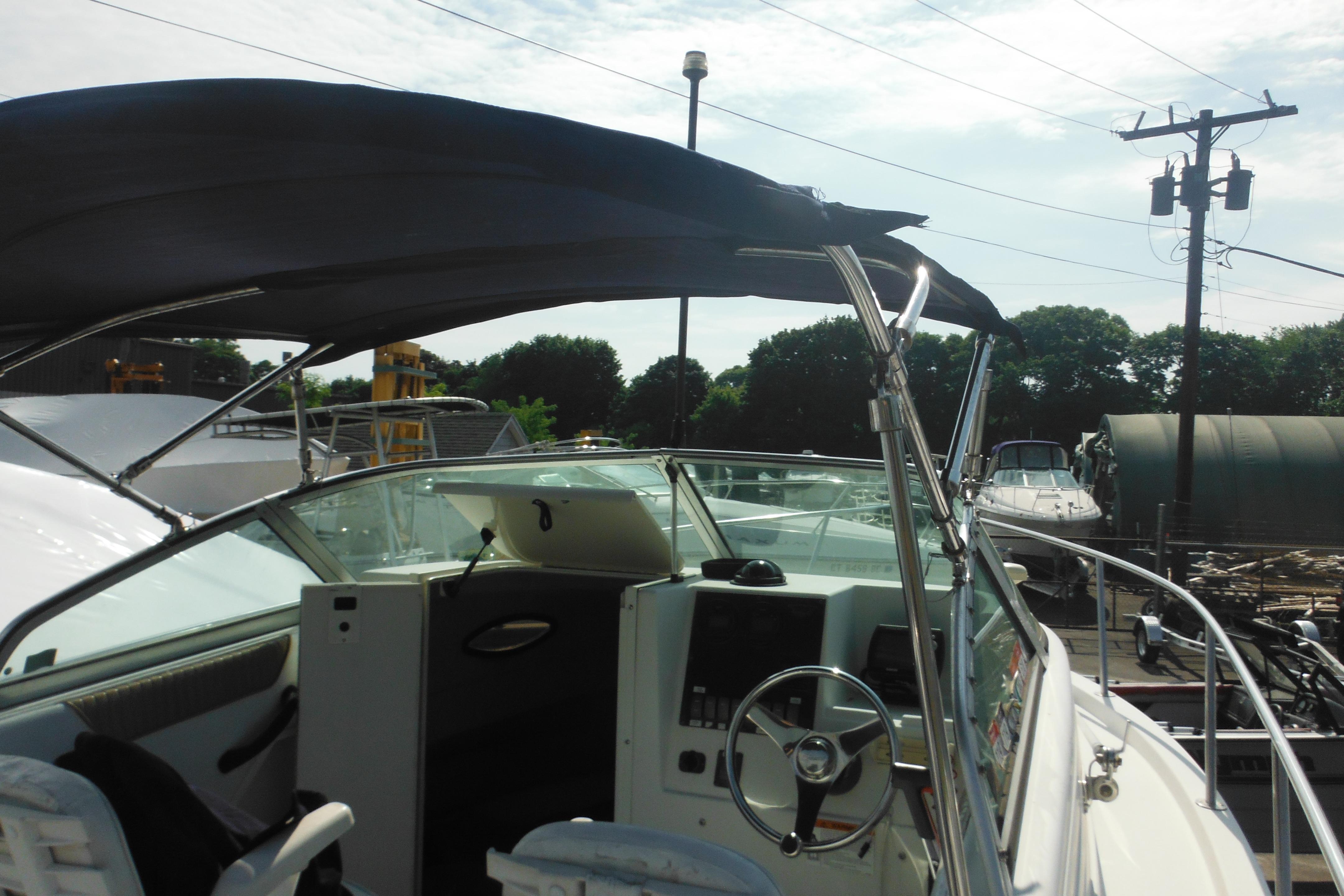 2005 Seaswirl Striper 2101 Walkaround O/B boat with canopy, docked outdoors.