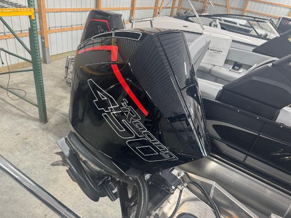 2025 Manitou LX boat with powerful Racing 450 engine in storage facility.