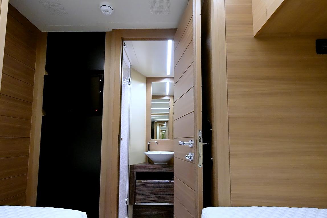 Interior of 2015 Pershing 92 yacht featuring modern wooden design and sleek bathroom.