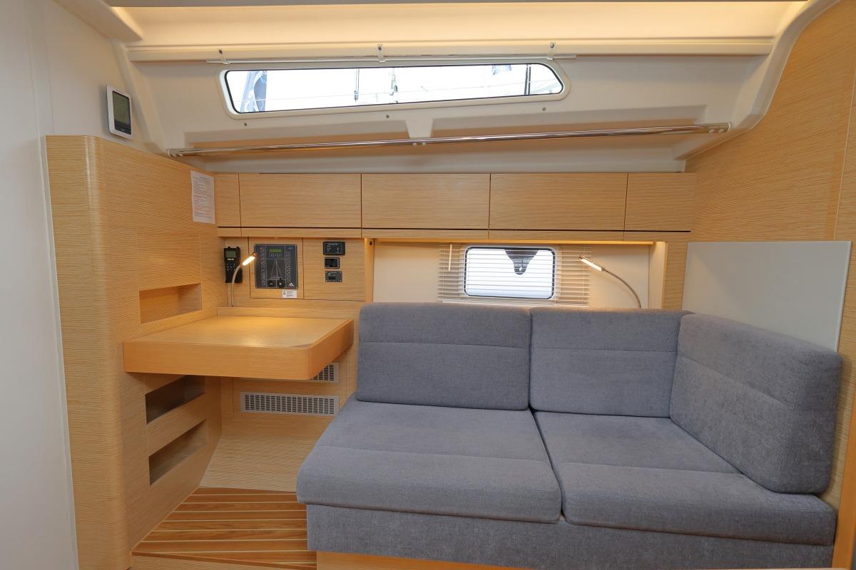 Modern interior of 2021 Hanse 388 yacht with cozy seating and navigation station.