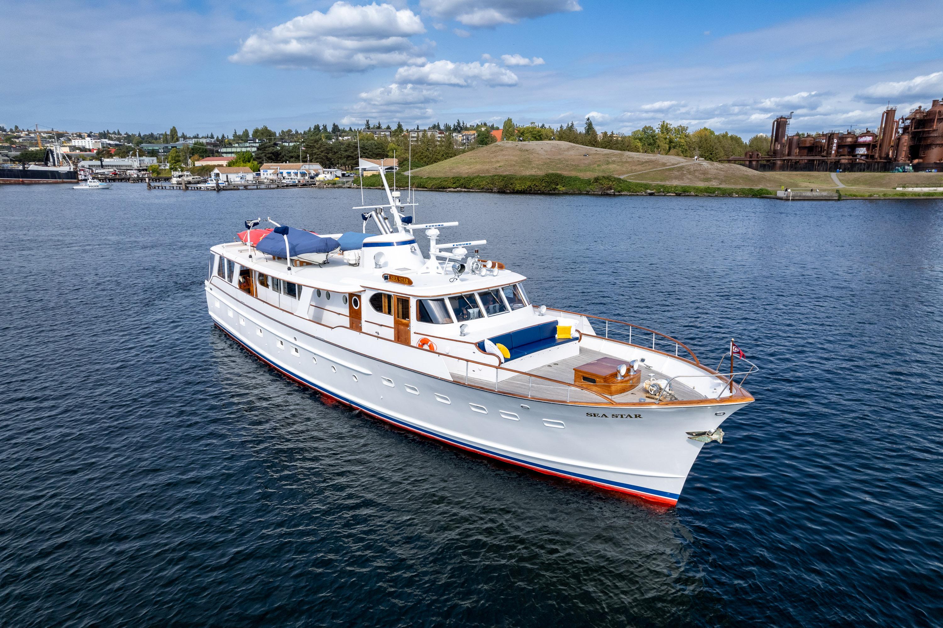 1965 Burger Motoryacht cruising on a calm lake under a partly cloudy sky.
