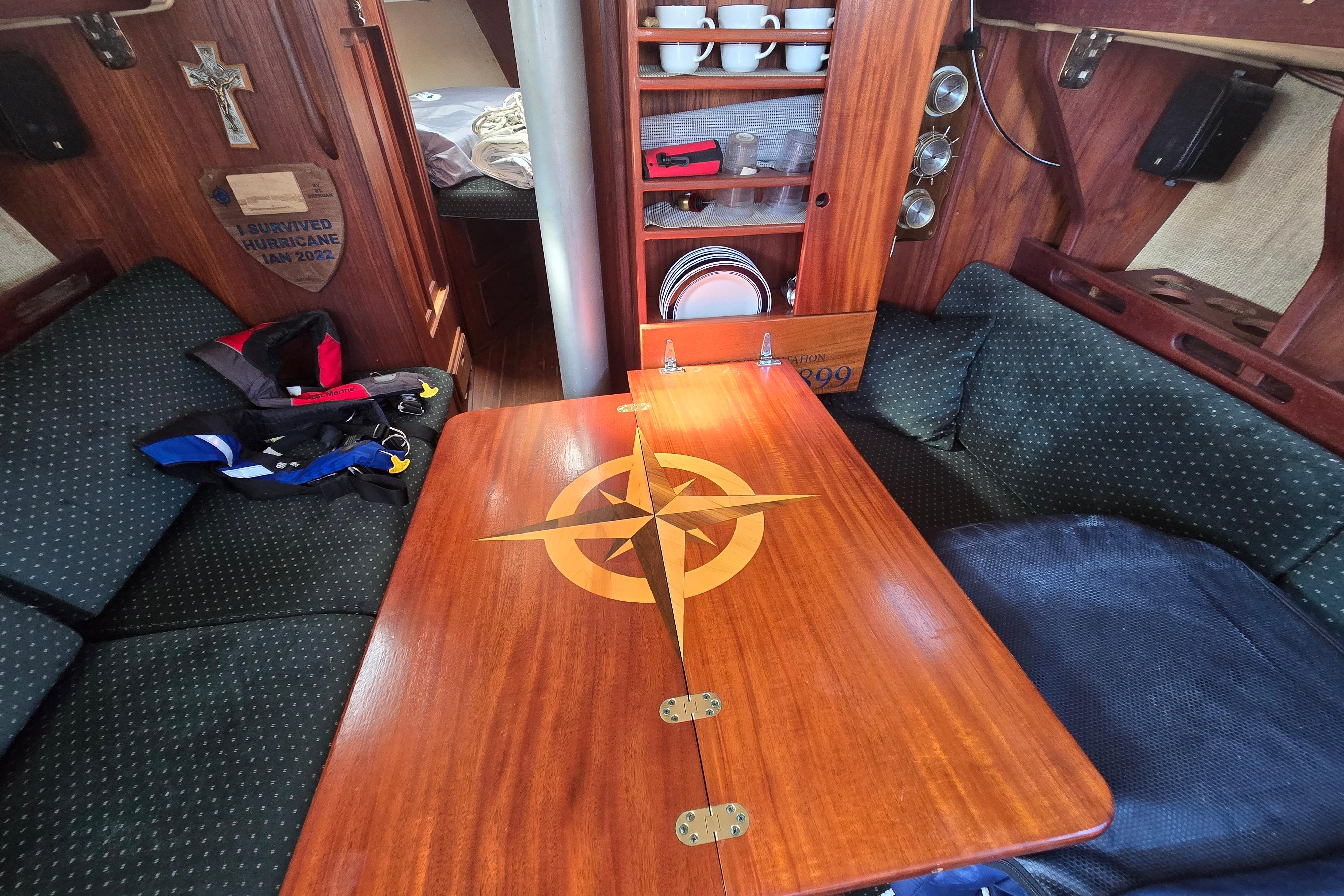 Interior of a 1981 Morgan 321 sailboat with wooden table and cozy seating.