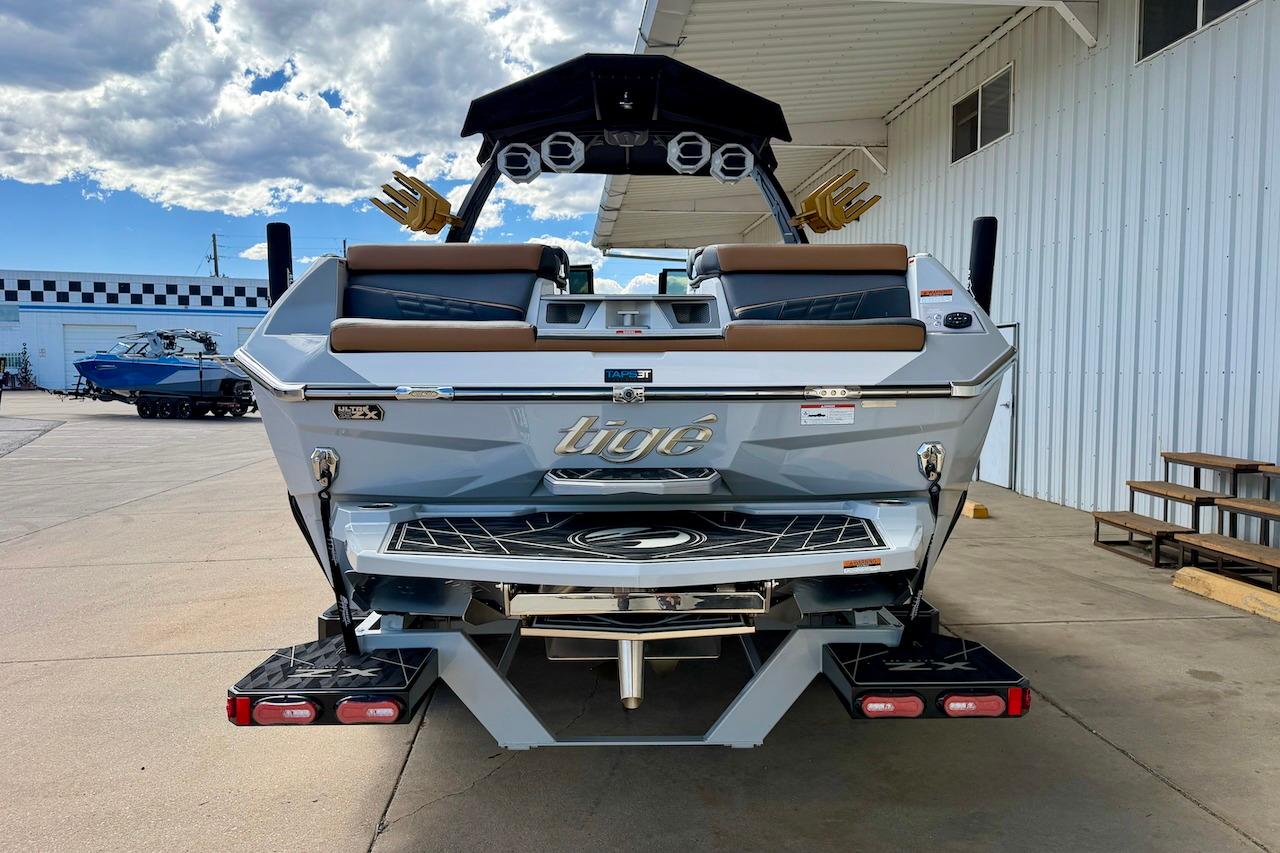 2025 Tigé Ultré 25ZX boat rear view at a marina under a cloudy sky.