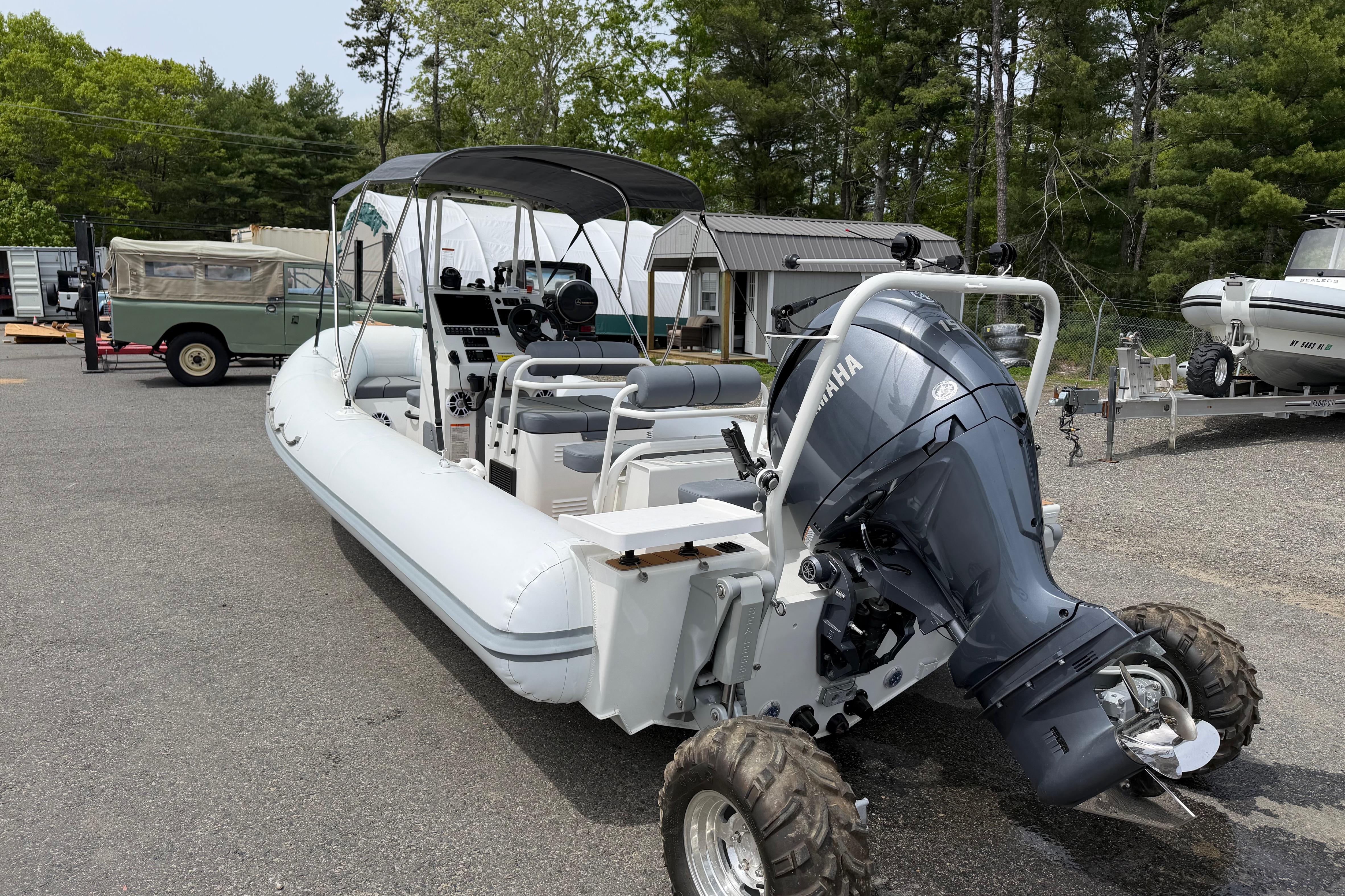 2024 Sealegs 7.1m RIB with Yamaha outboard motor on land, surrounded by trees.