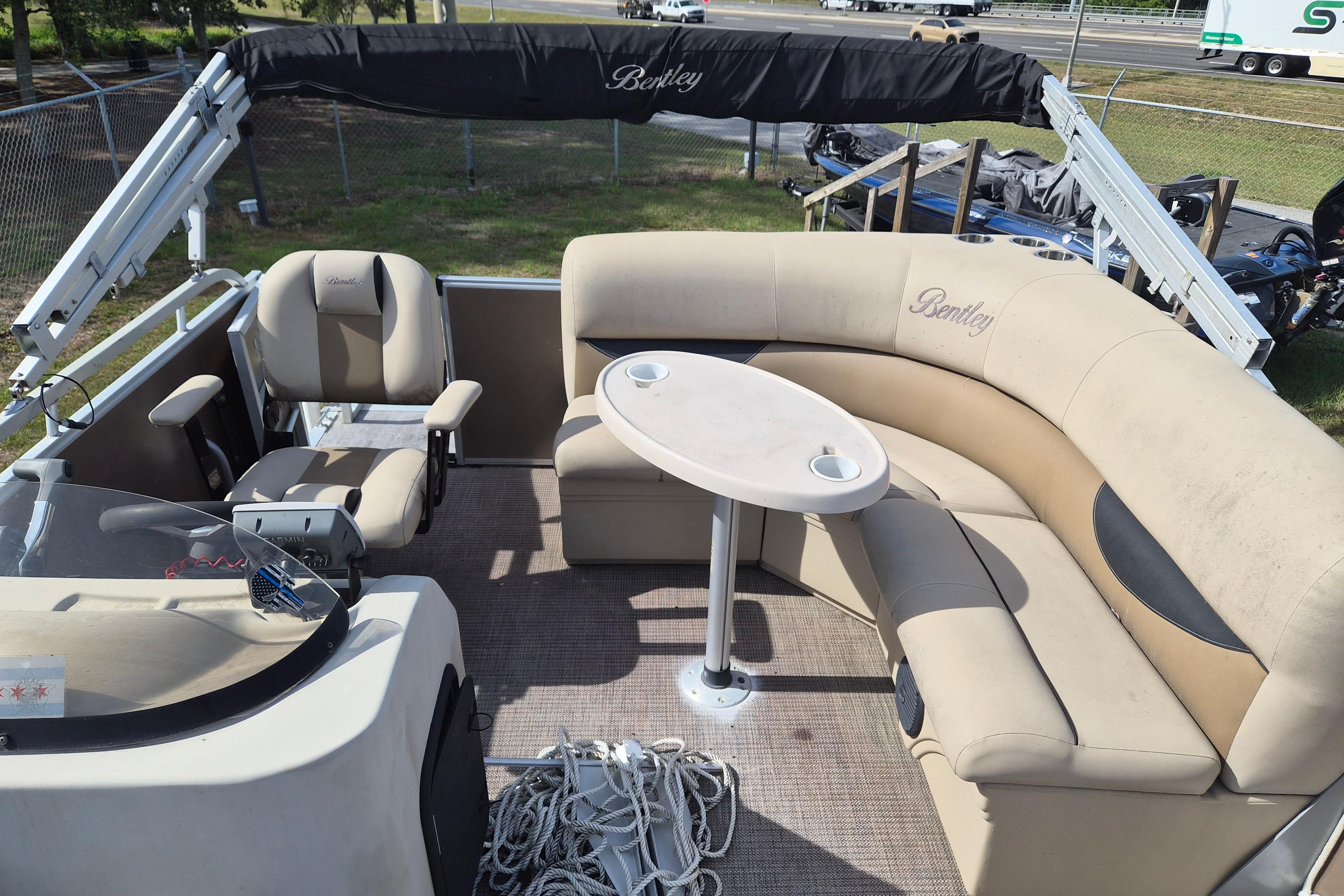 2004 Bentley Pontoons 180 CRUISE interior with beige seating and table, showcasing comfort and style.
