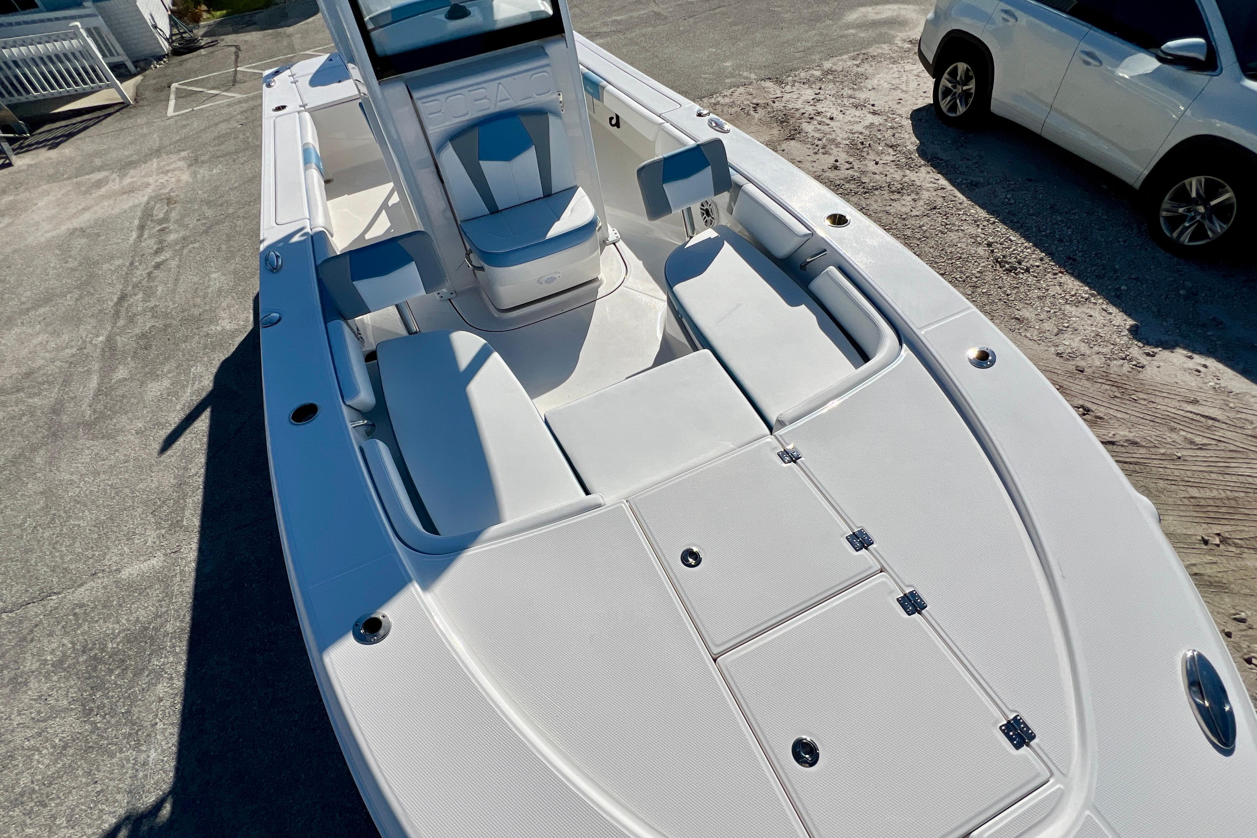 2026 Robalo 246 Cayman boat with spacious deck and seating, parked on concrete.