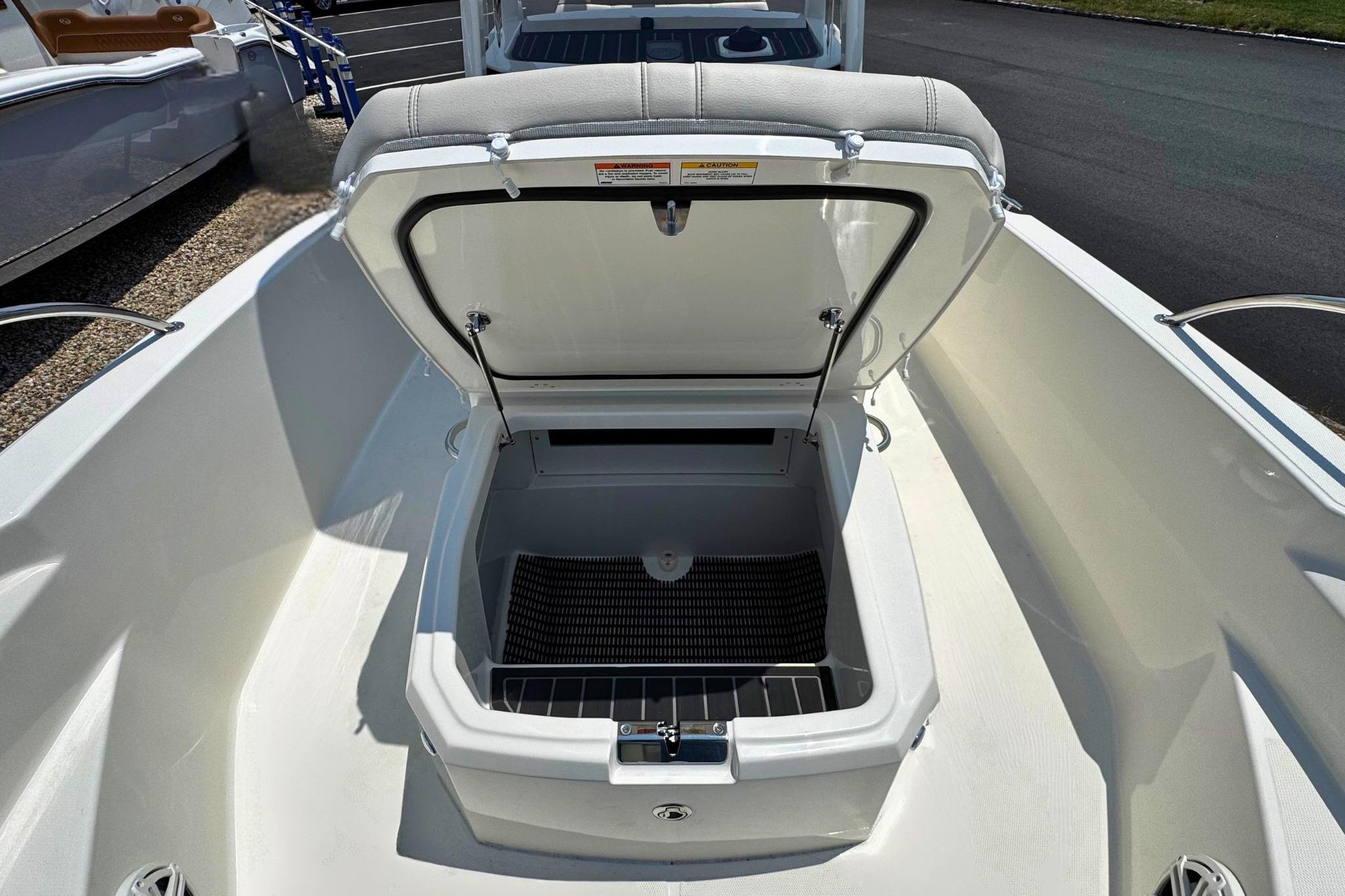 2026 Boston Whaler 220 Dauntless boat with open storage compartment on deck.