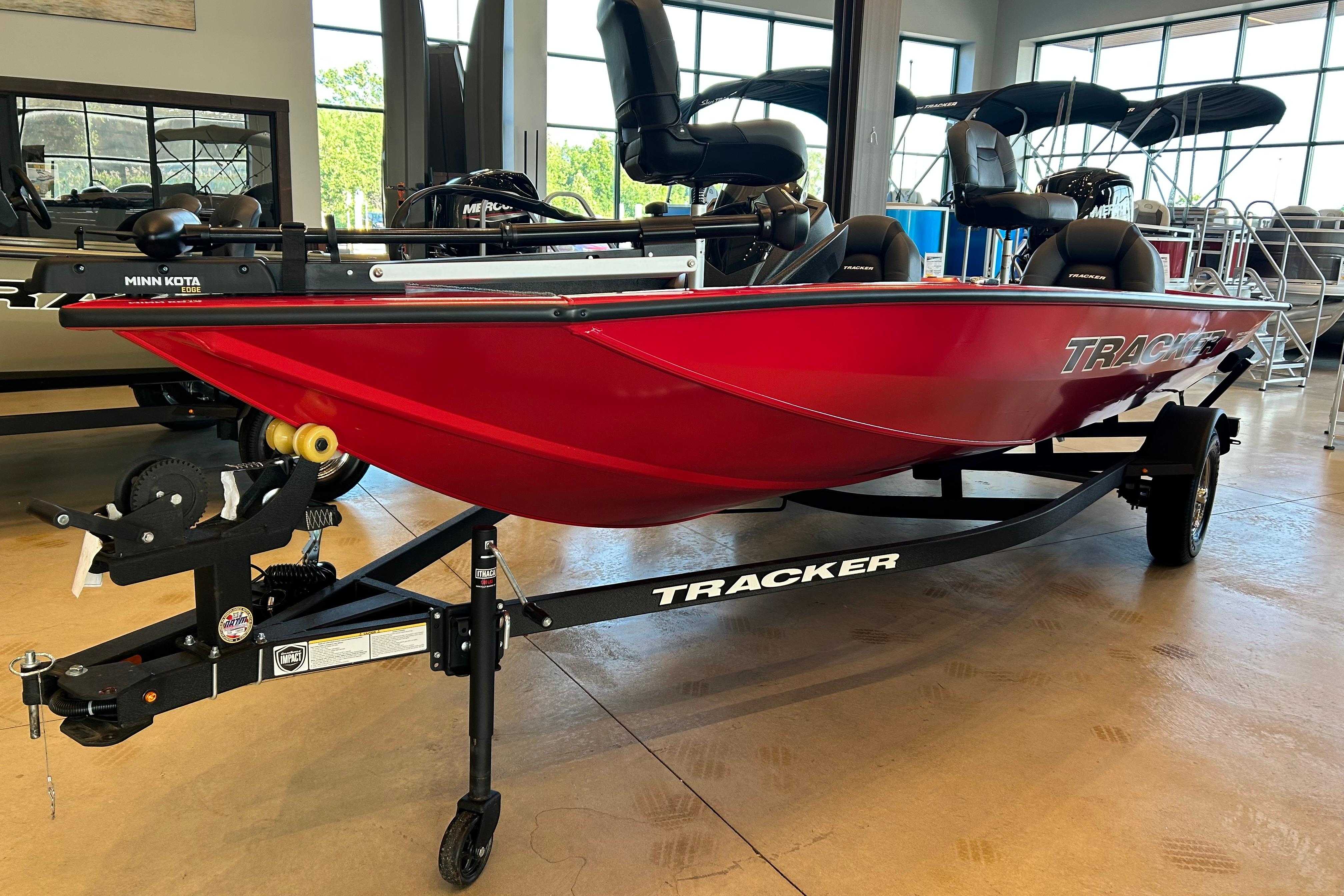 2026 Tracker Pro Team 175 boat in showroom, vibrant red color, on trailer.