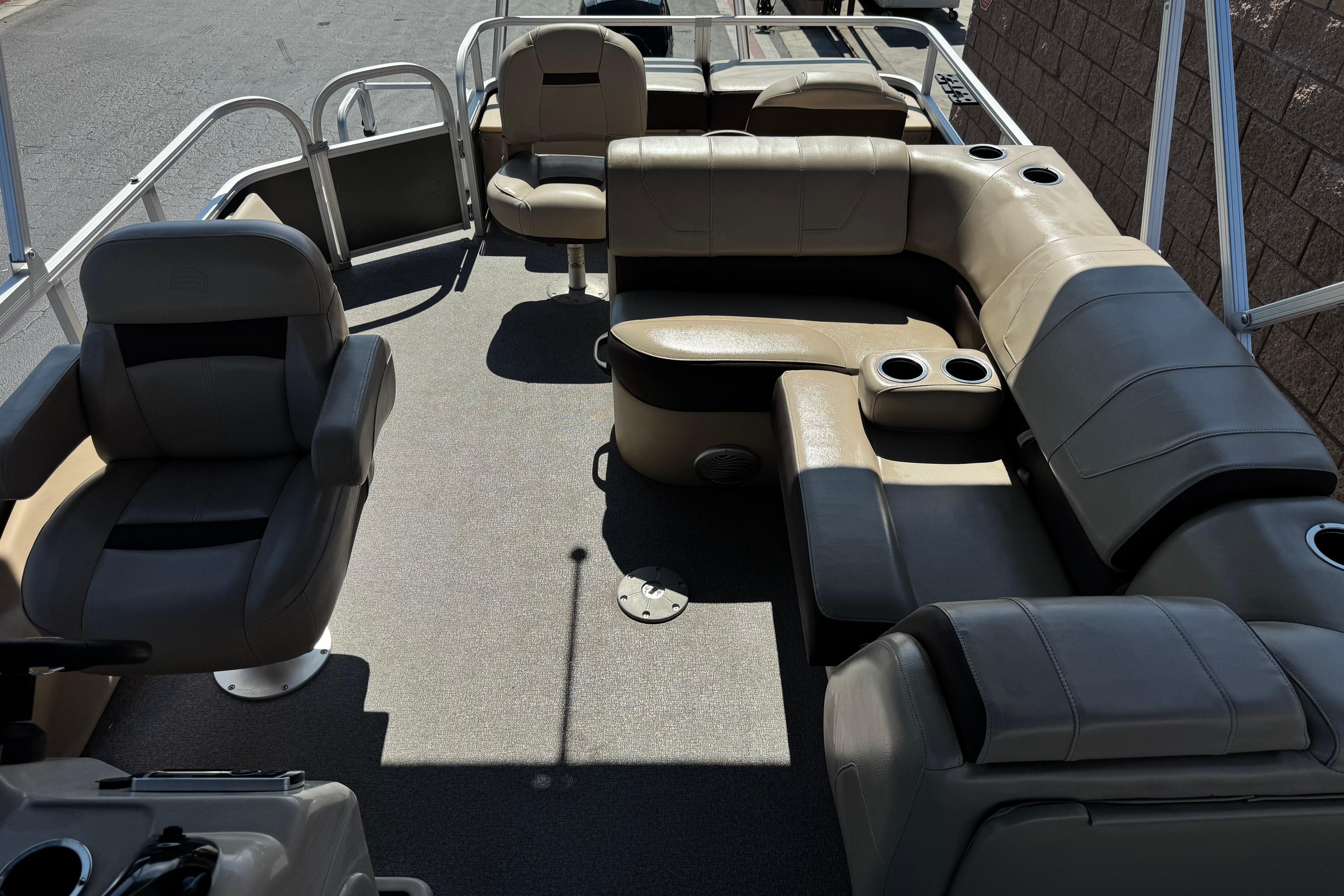 2018 Sun Tracker SportFish 22 DLX pontoon boat interior with cushioned seating and cup holders.