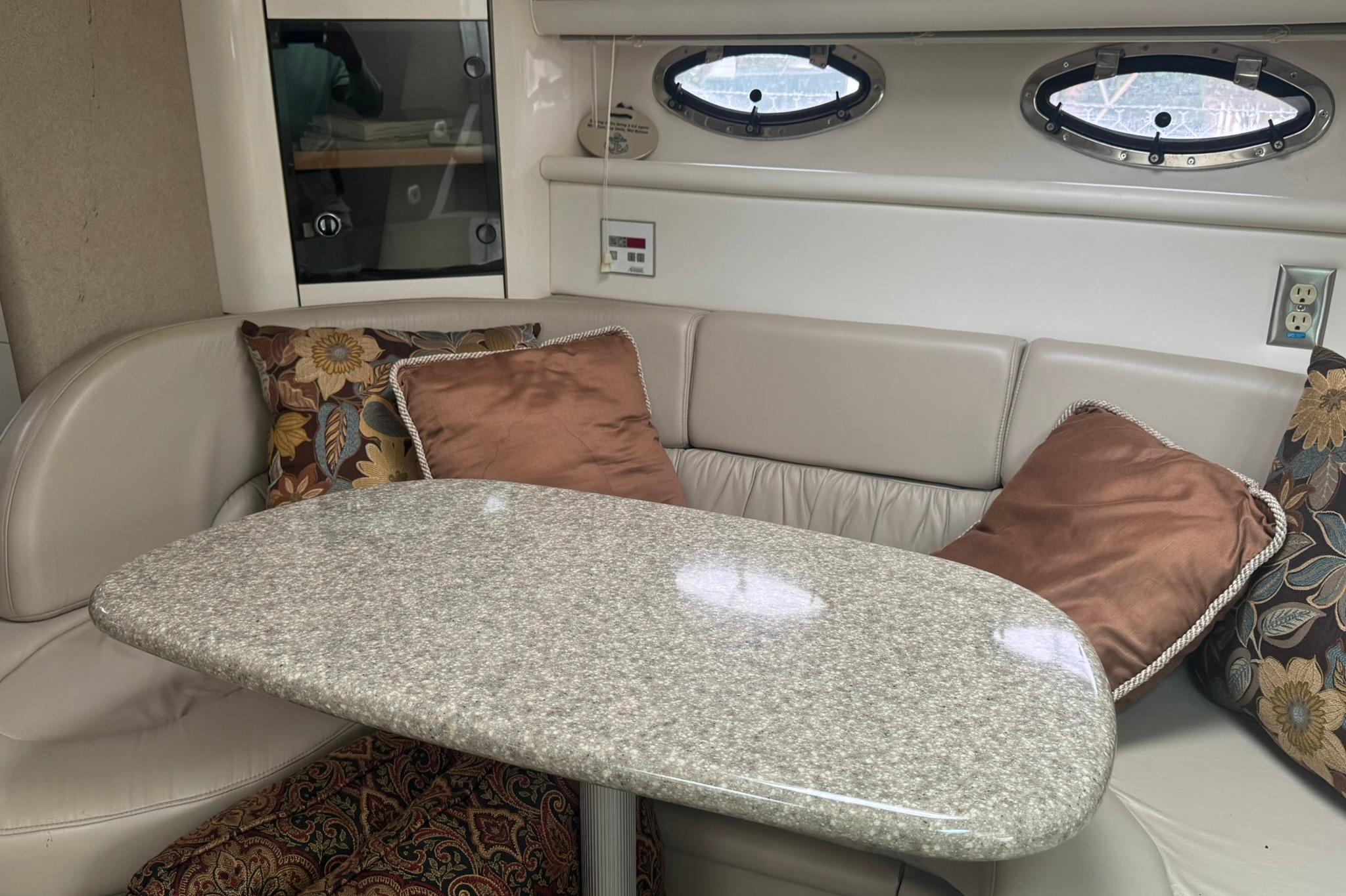 1998 Maxum 3700 SCR yacht interior with plush seating, decorative pillows, and a sleek table.