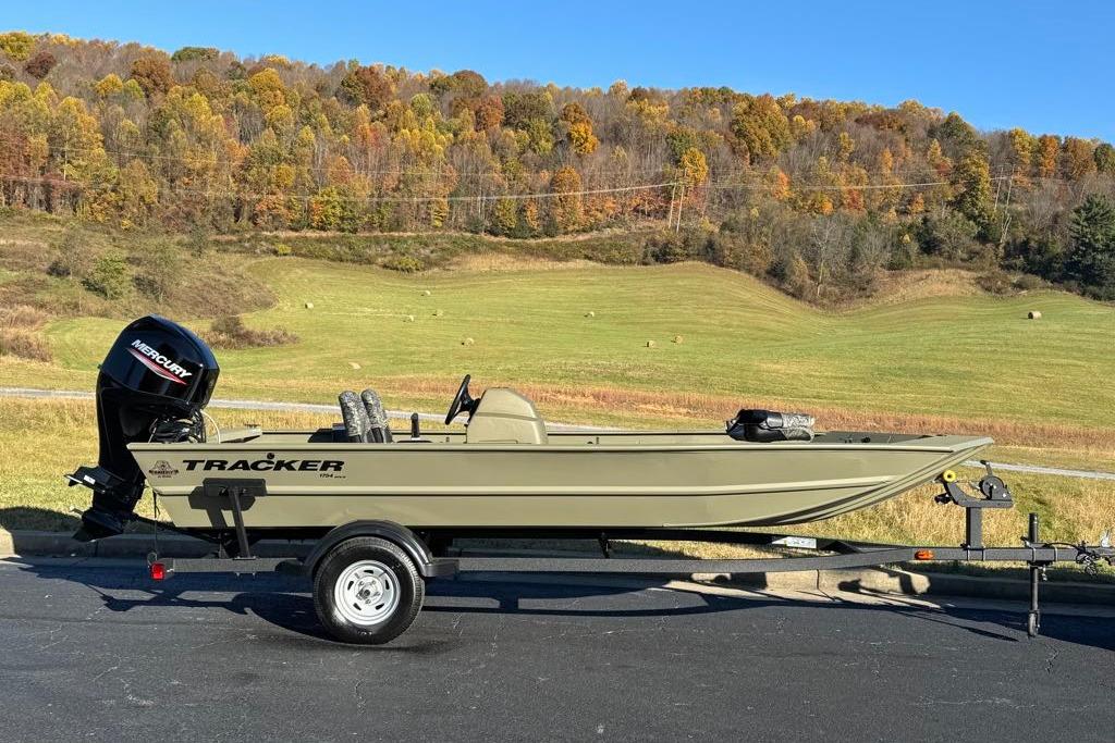 2026 Tracker Grizzly 1754 SC boat on trailer, scenic autumn landscape background.