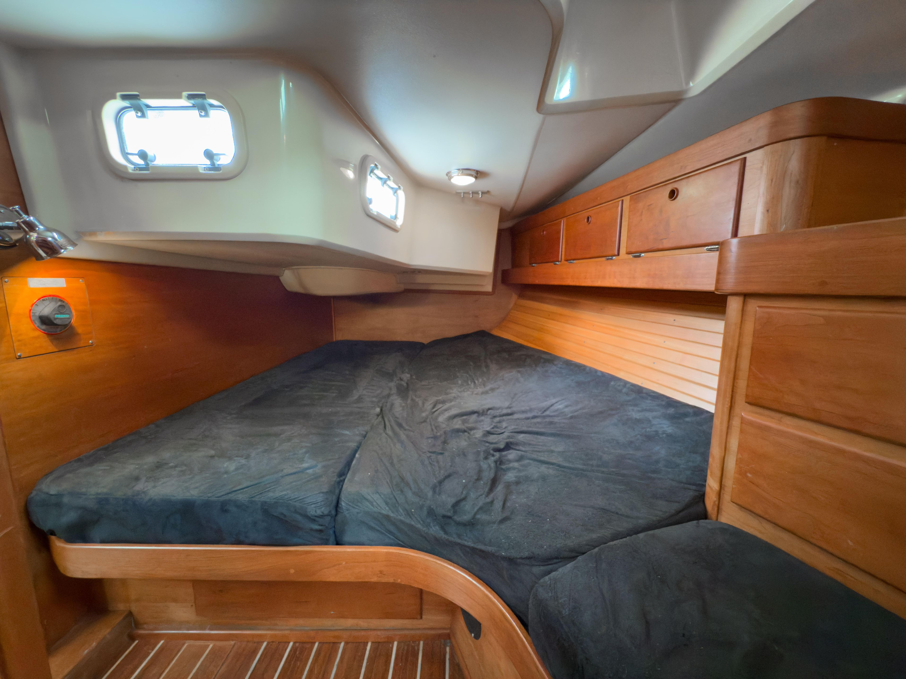 Cozy cabin interior of 1997 Sabre 402 sailboat with wooden finish and portholes.