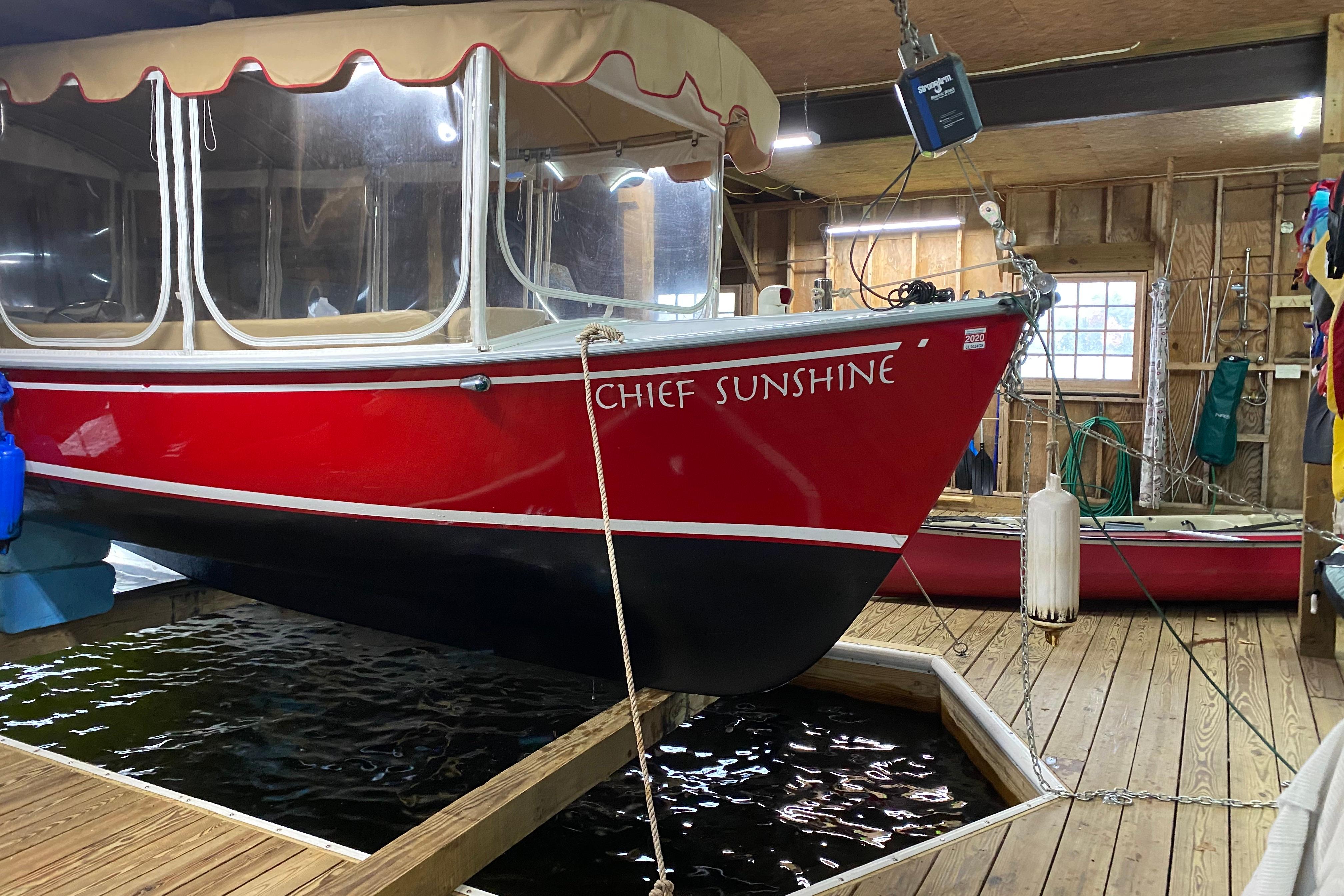 Red 2004 Duffy 21 Classic boat named "Chief Sunshine" docked indoors.