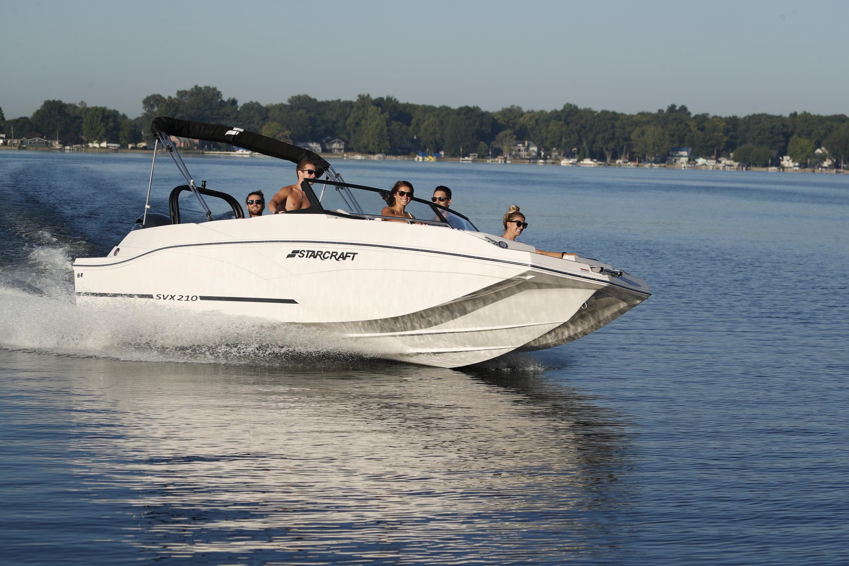 2026 Starcraft SVX 210 DC OB boat cruising on a serene lake.