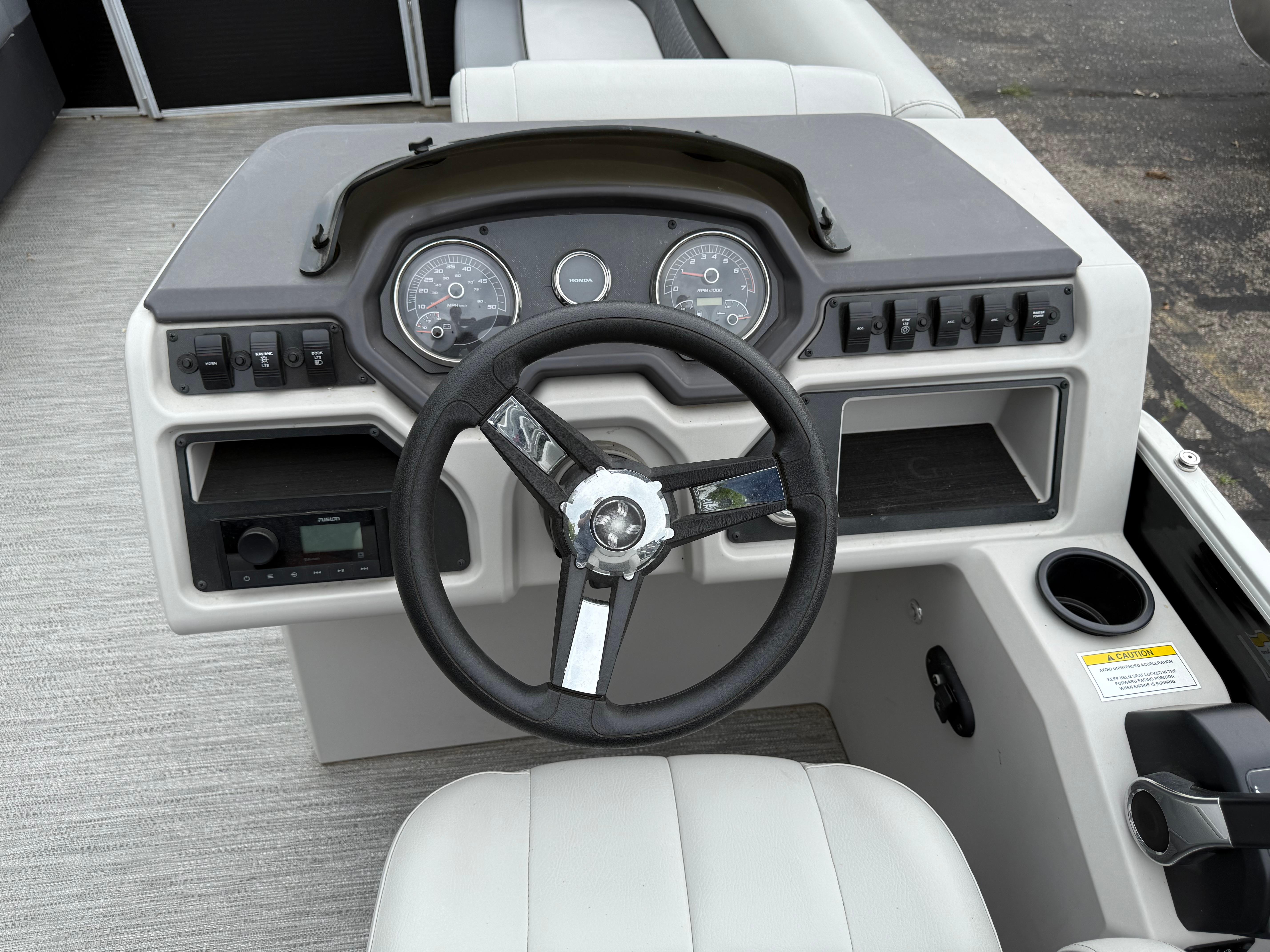 2023 Godfrey Sweetwater boat dashboard with steering wheel and control panel.