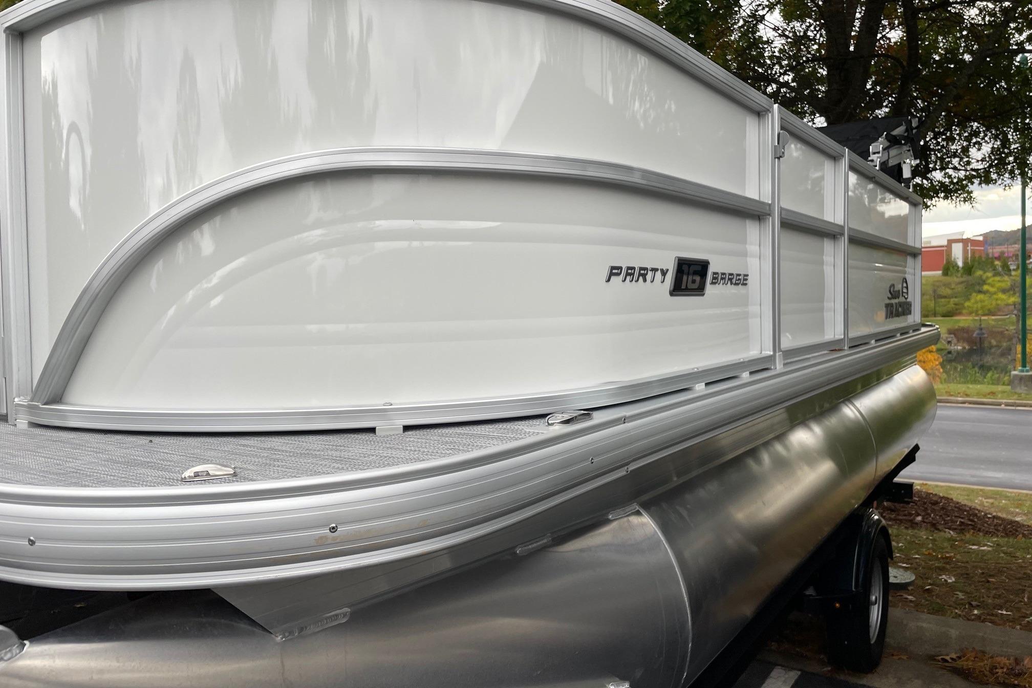 2026 Sun Tracker Party Barge 16 DLX pontoon boat, side view, parked outdoors.
