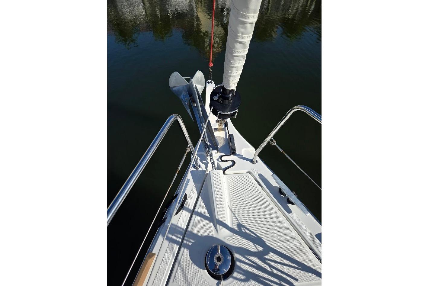 Bow of 2023 Beneteau Oceanis 38.1 sailboat with anchor and railing.